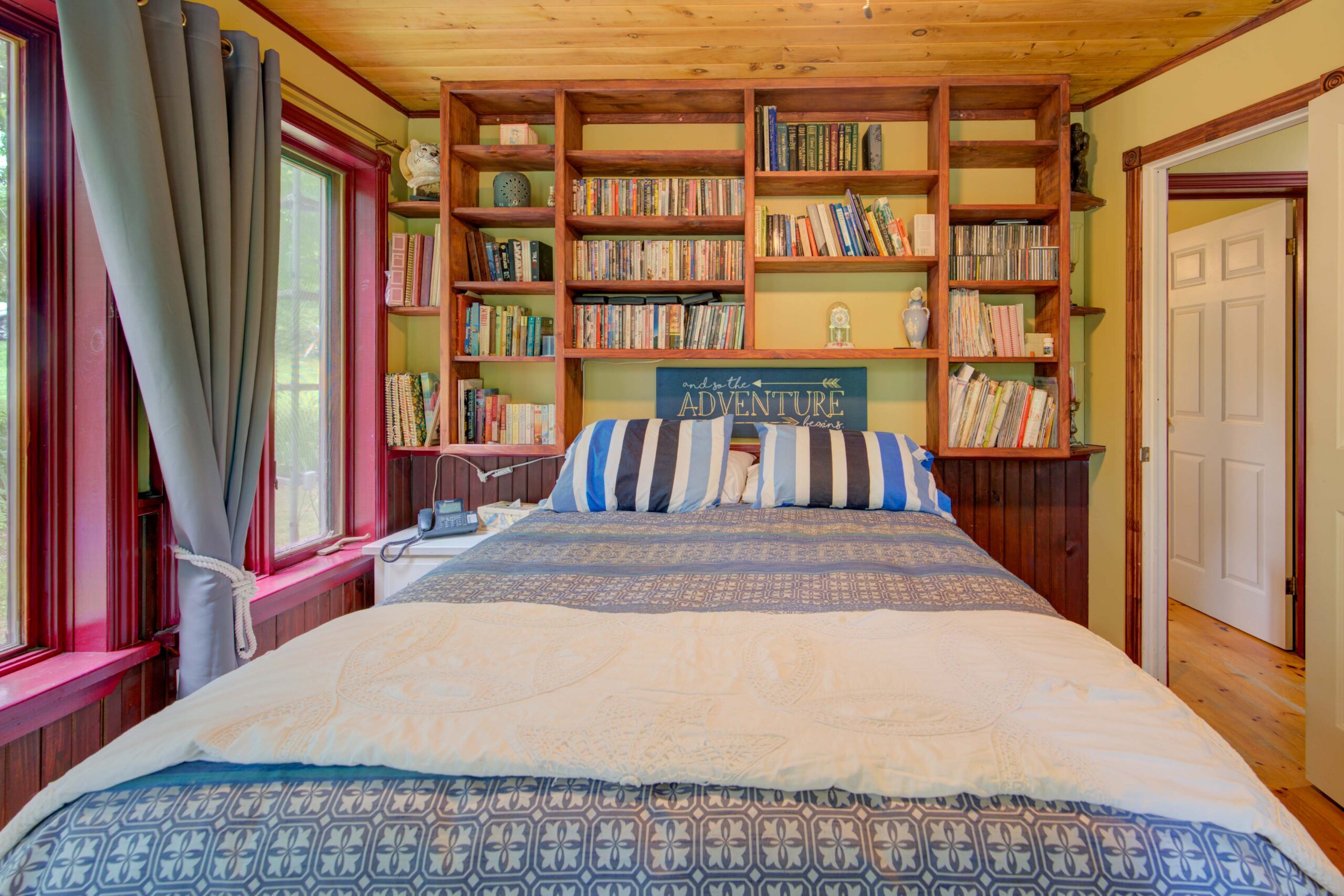 A large bed with built-in bookshelves behind it