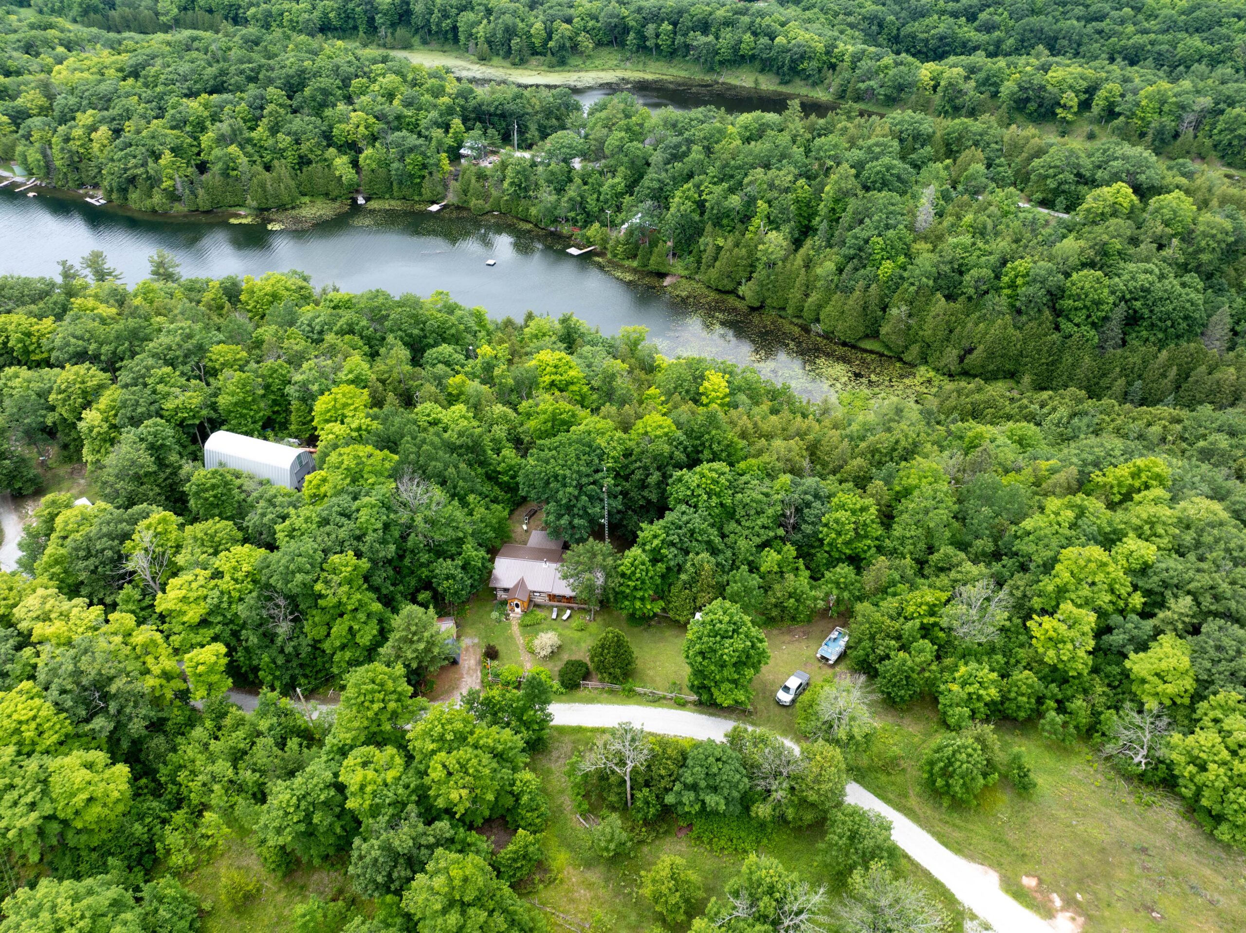 Aerial view of a small cabin in a green forested area
