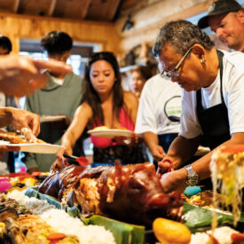 Family serving themselves food from the boodle fight