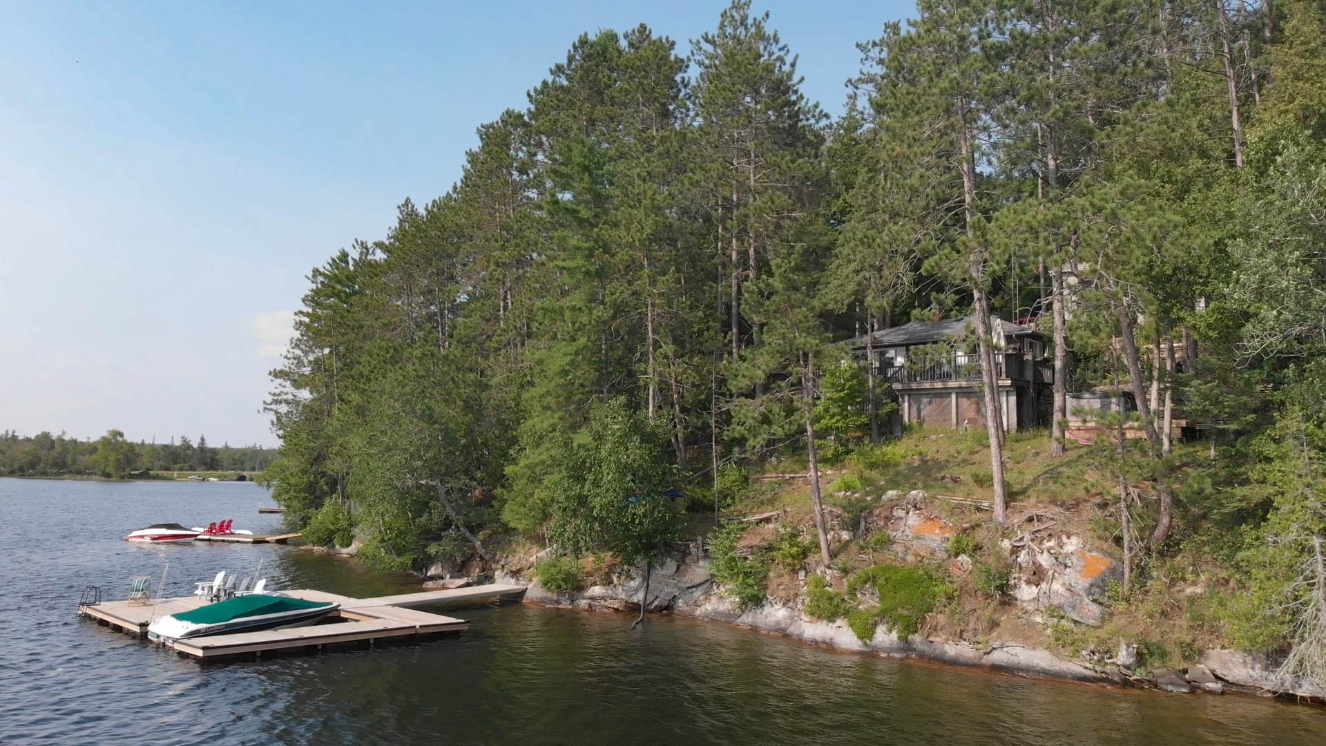 A cottage partially hidden by trees on an island
