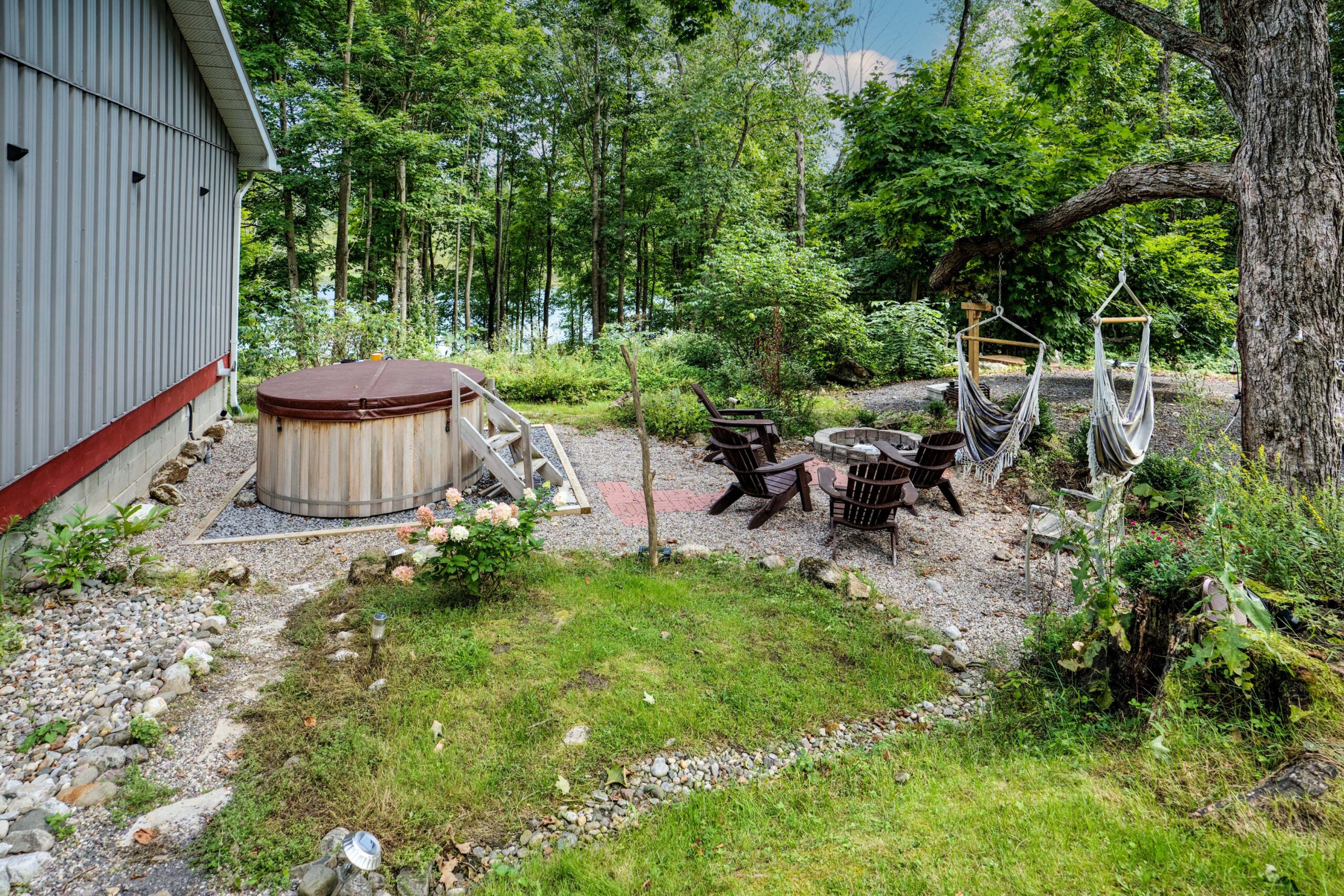 A barrel hot tub in a landscaped area