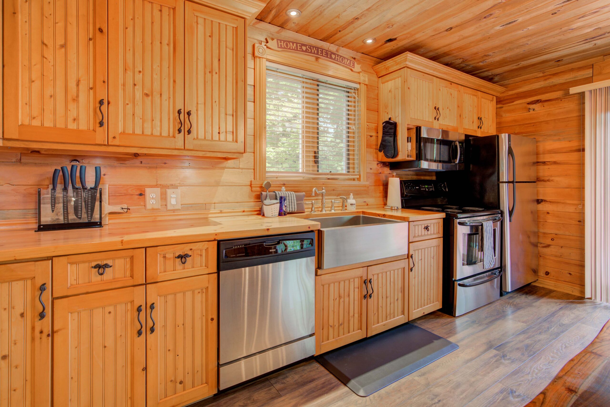 A wood-panelled wall of cabinets and a stainless steel dishwasher