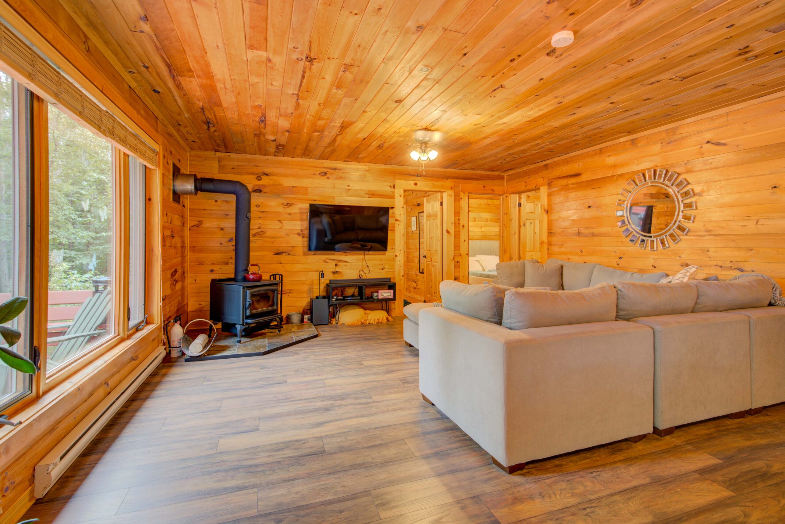 A cream coloured couch faces a wood stove