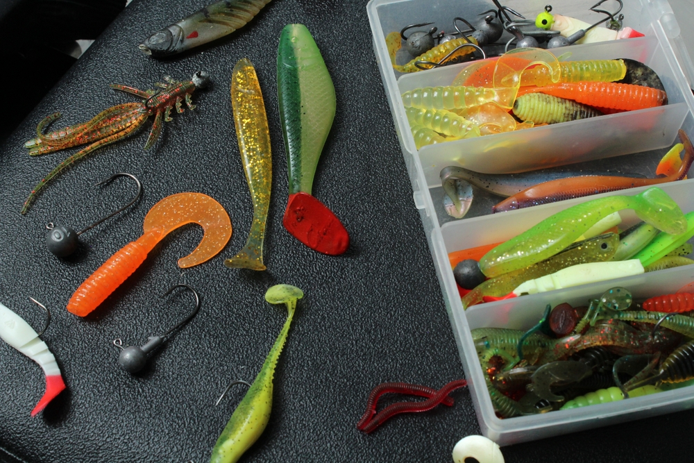 A tackle box and bench with a variety of fishing bait