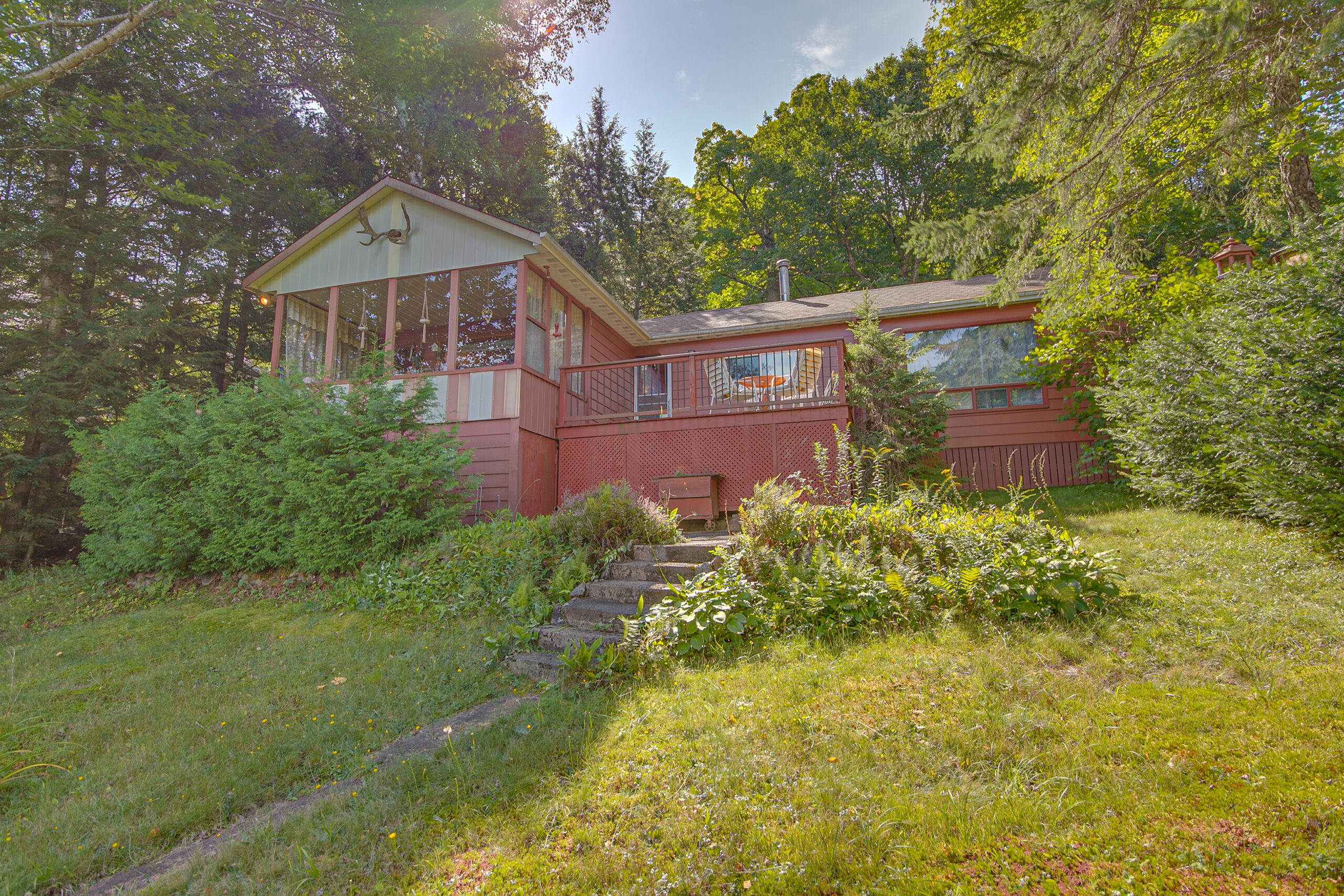 A red bungalow cottage on a grassy hillside