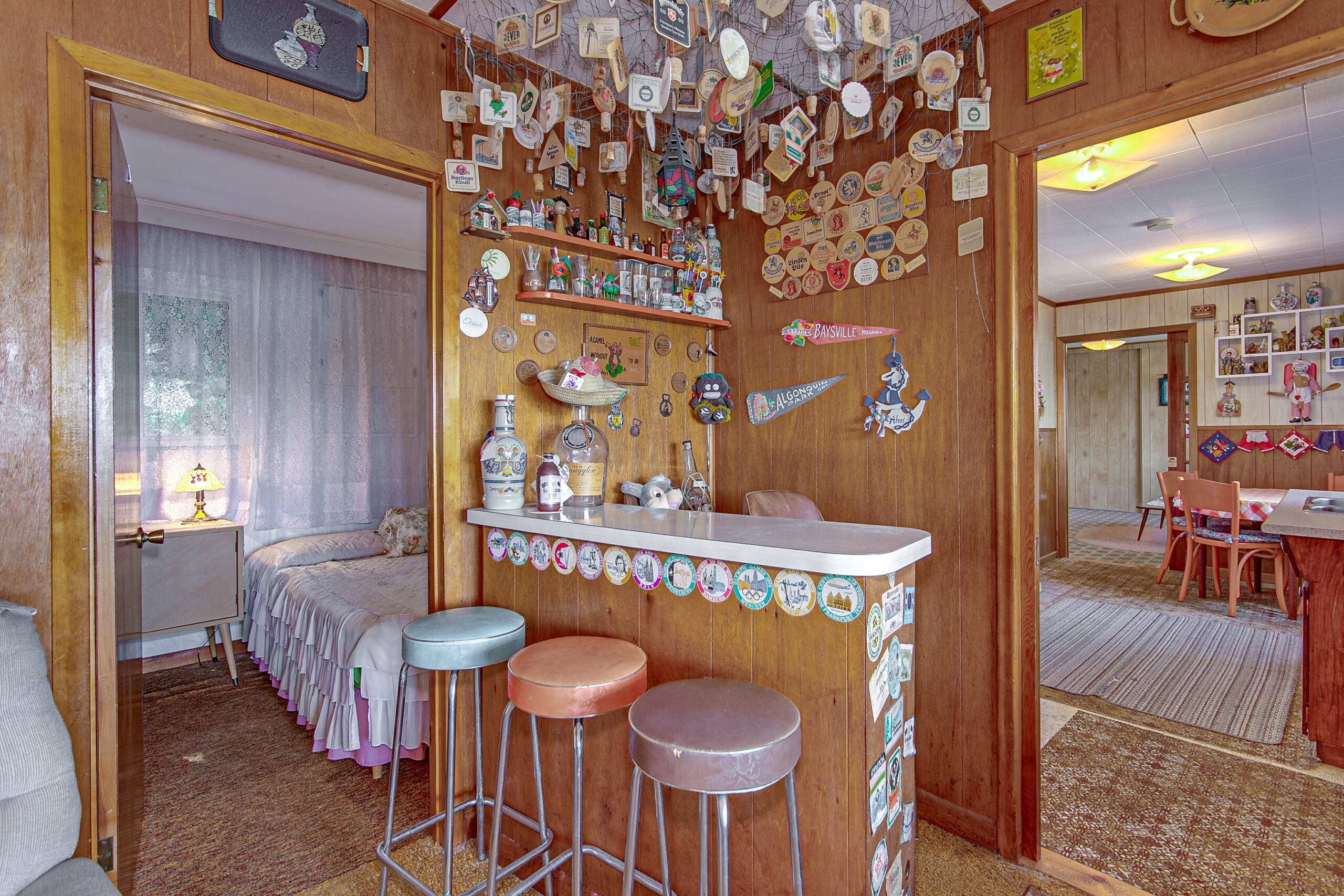 A small wood bar with three colourful bar stools
