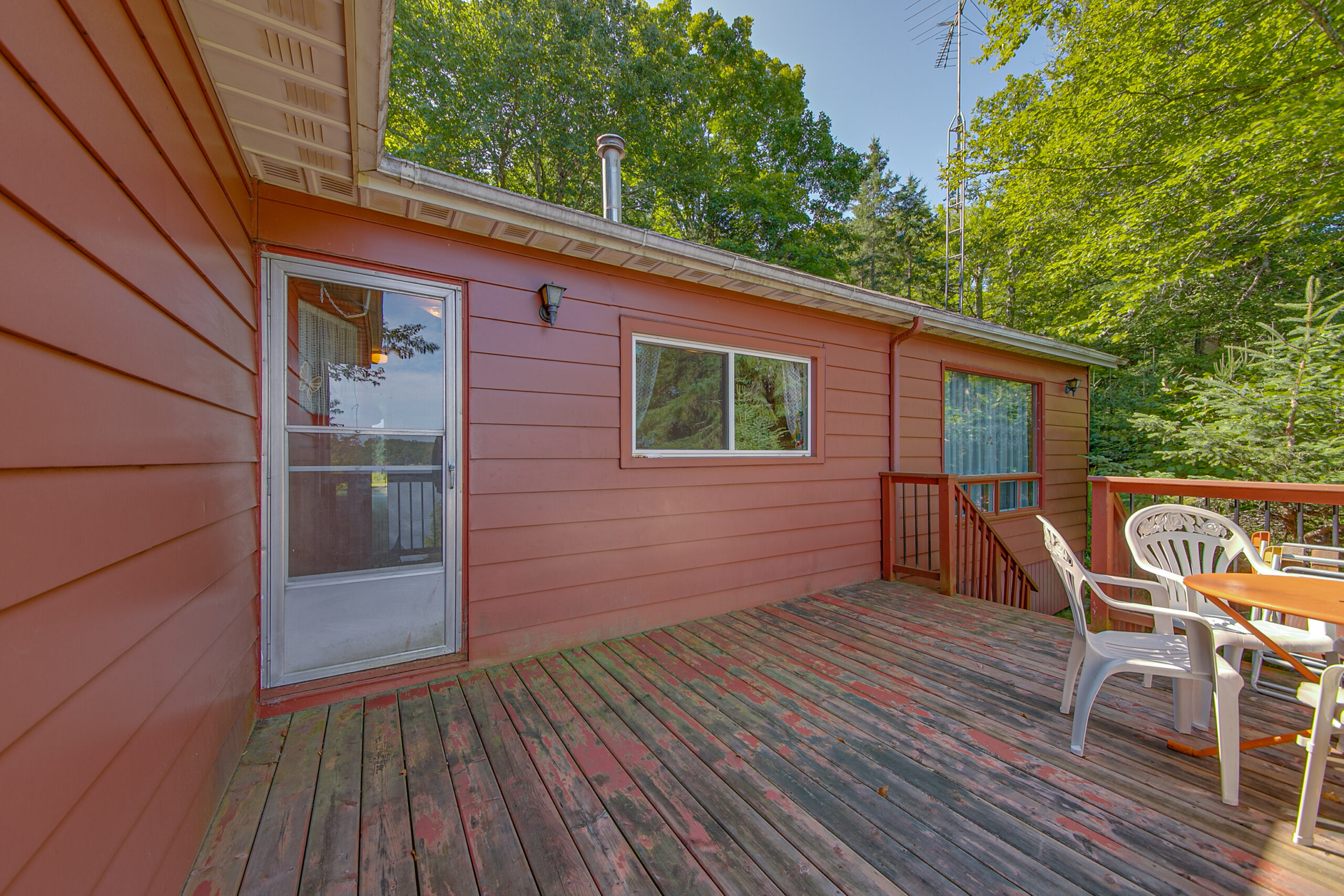 A brown and red deck attached to a red cottage