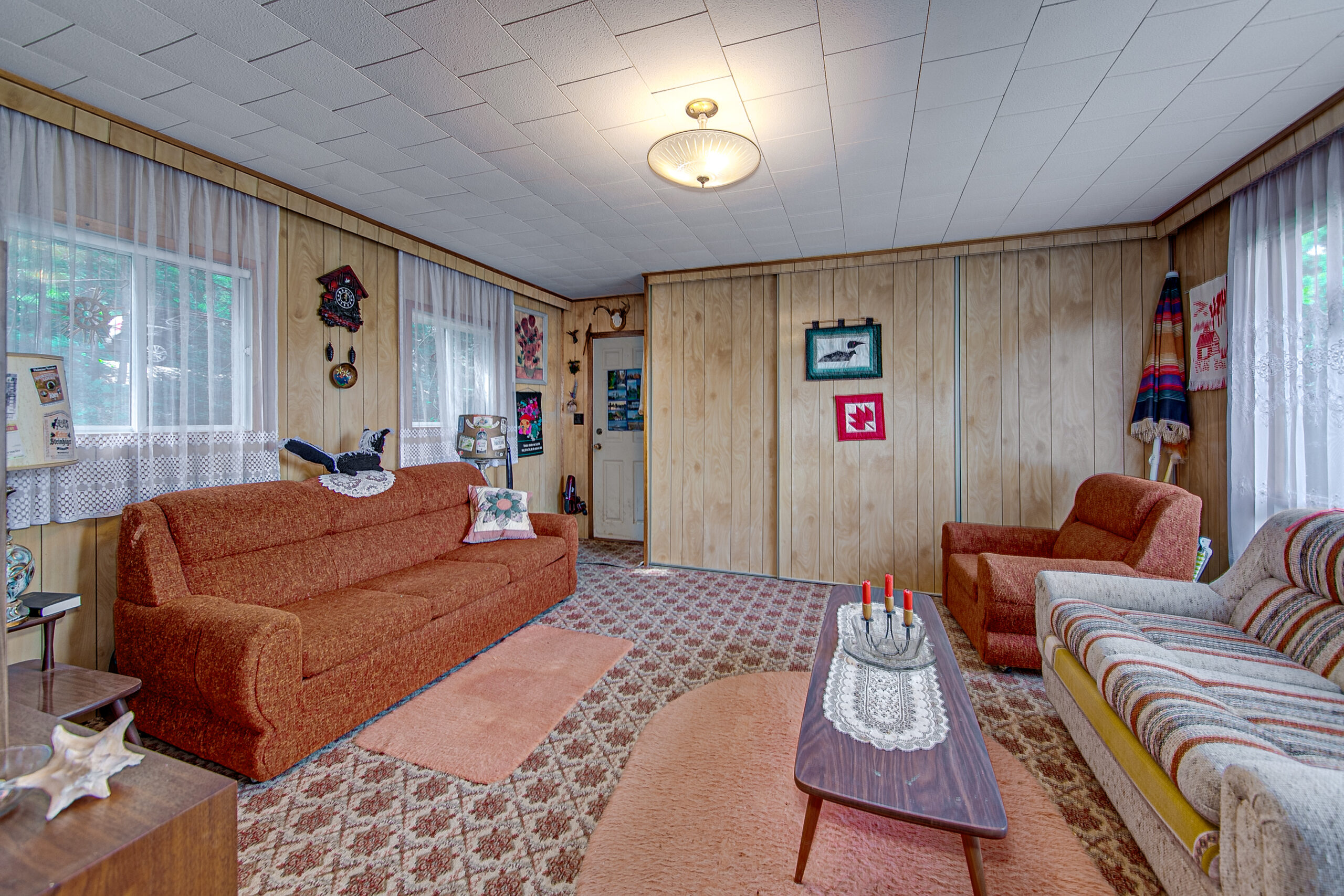 A living room with a spotted carpet and an orange couch