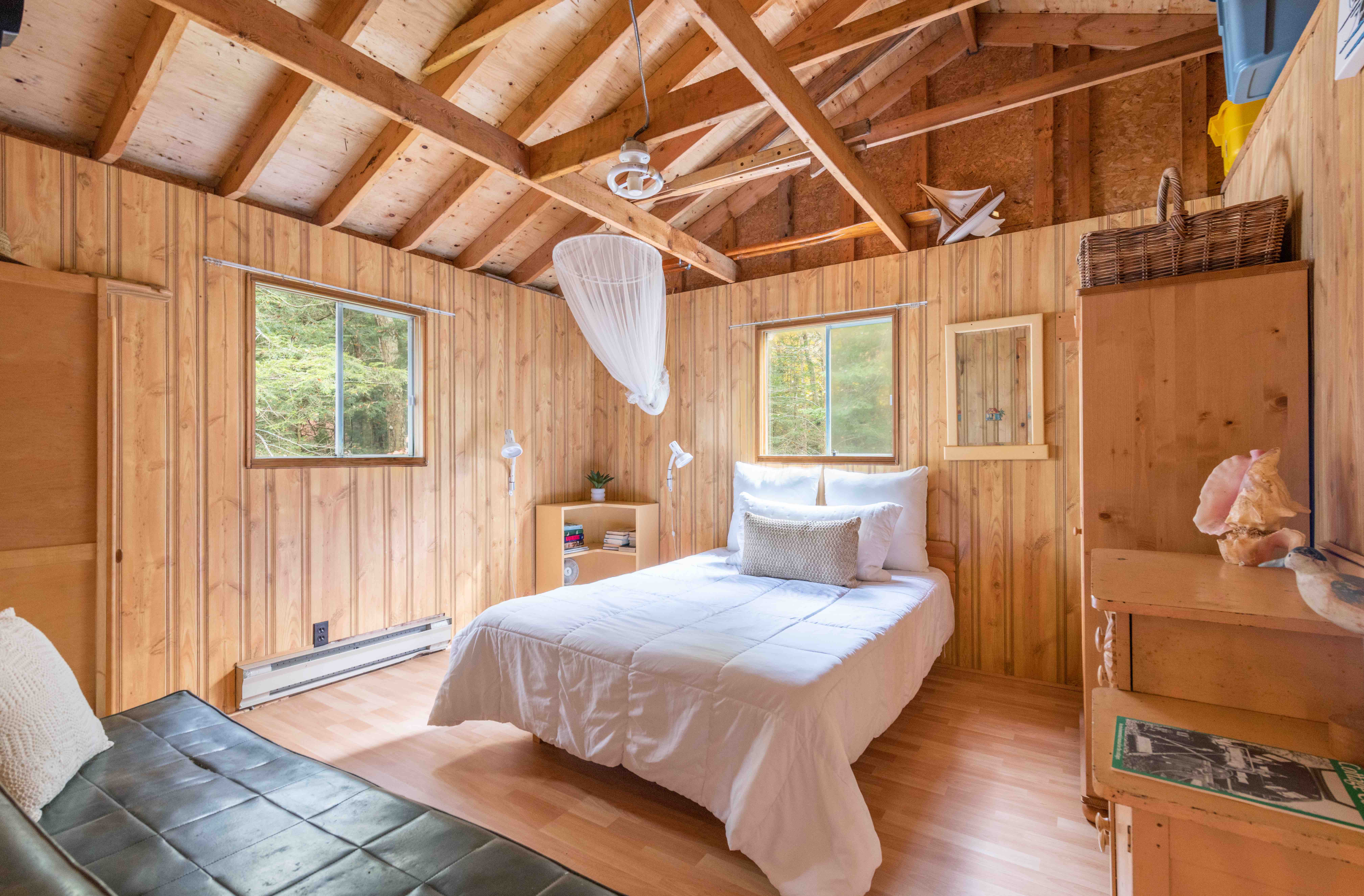 A white bed in a wood room