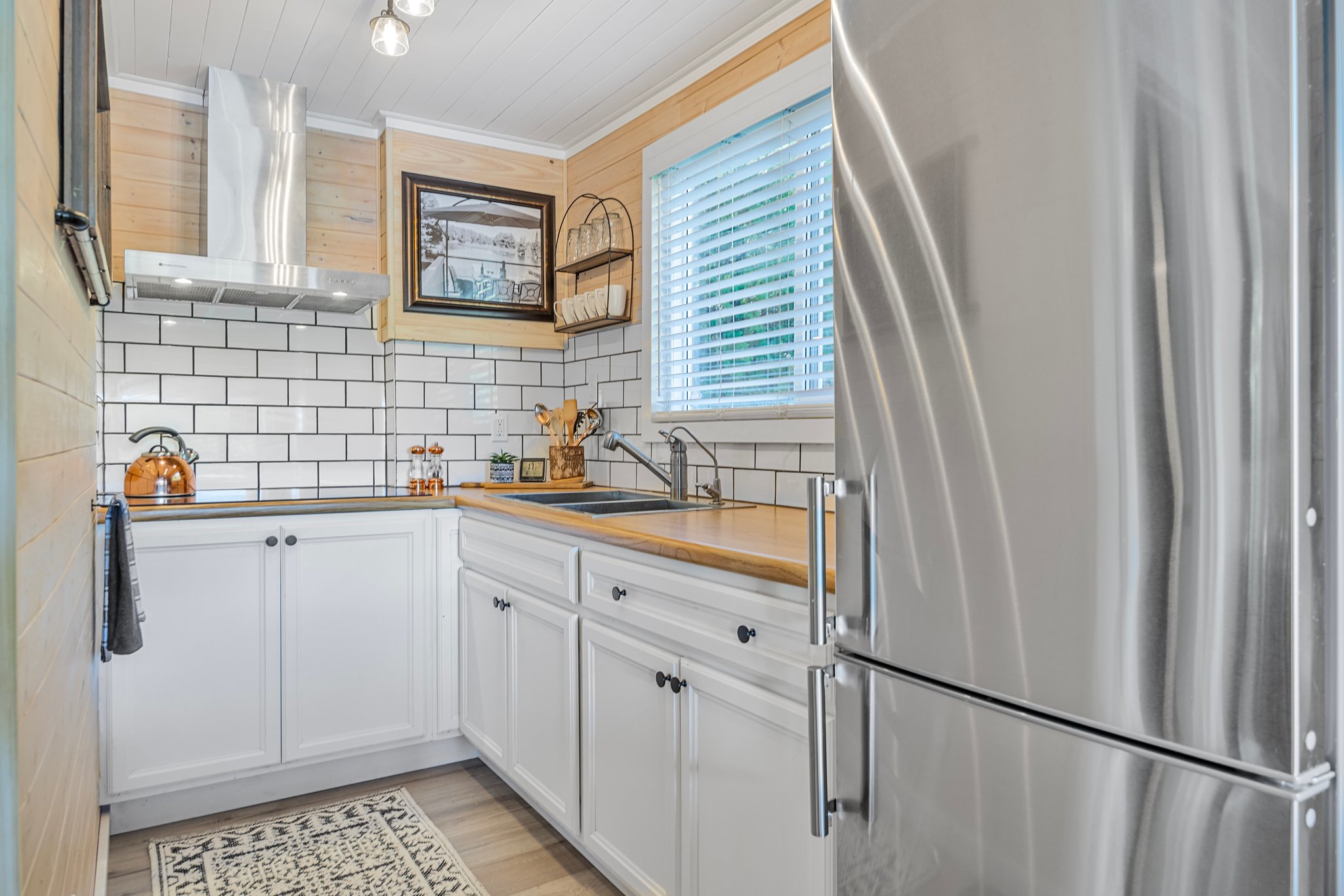 A bright kitchen with white cabinets and subway tiles