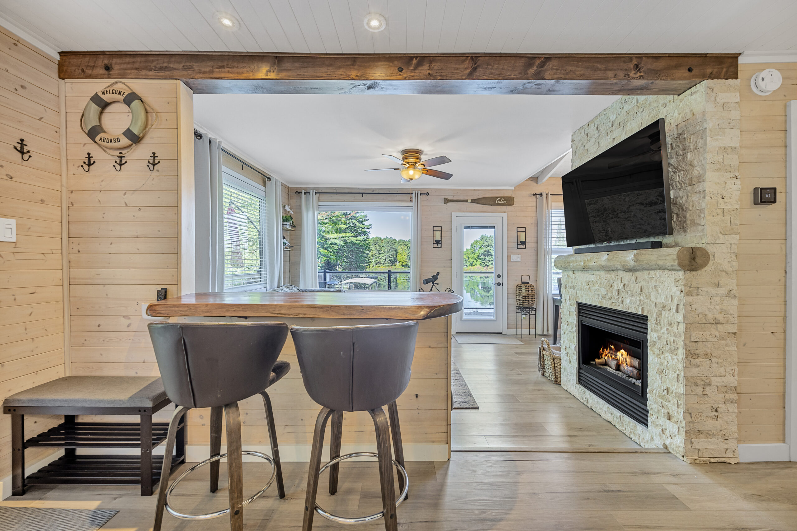 Two grey bar stools facing a high top counter. To the right, a fireplace with a flat screen TV above