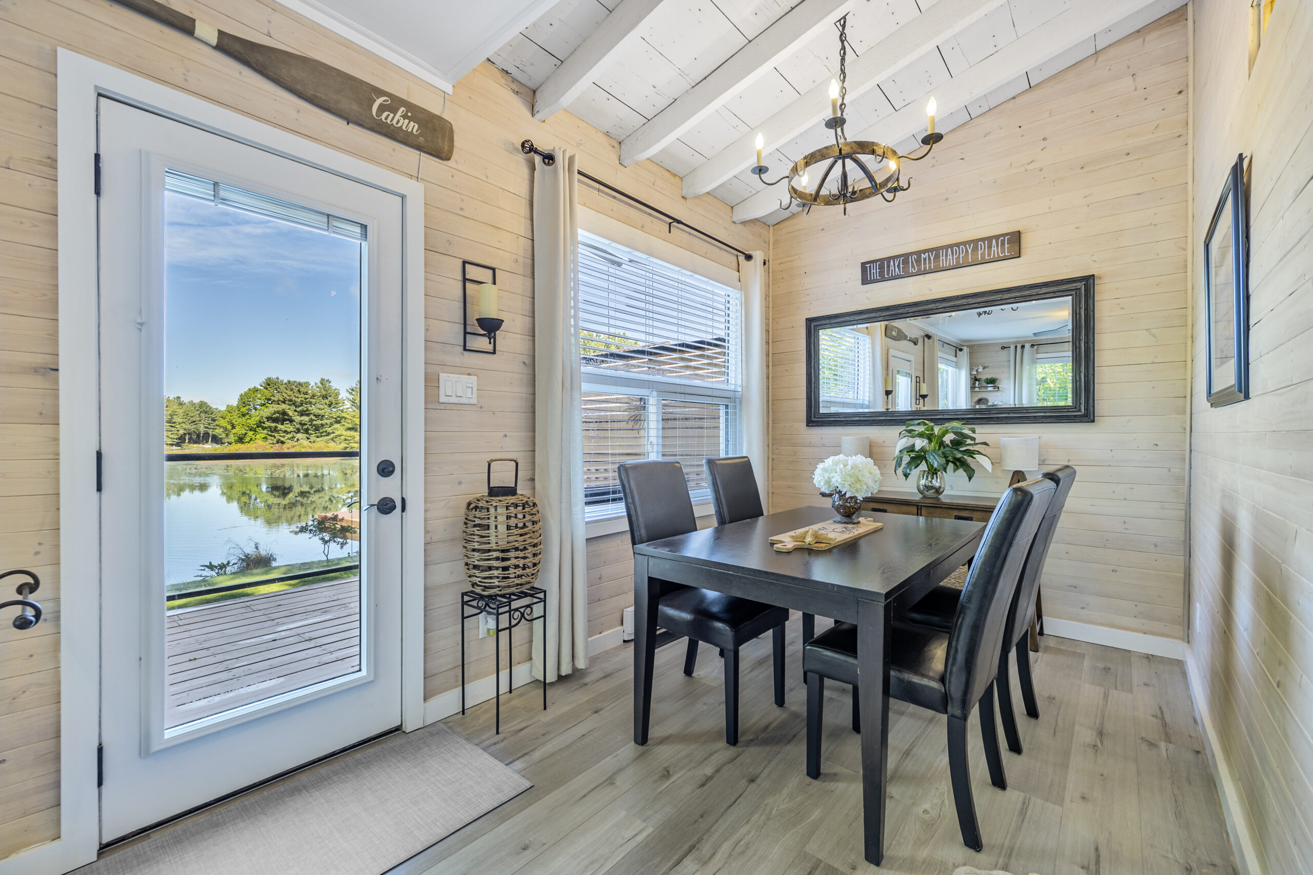 A small rectangular dining table surrounded by windows