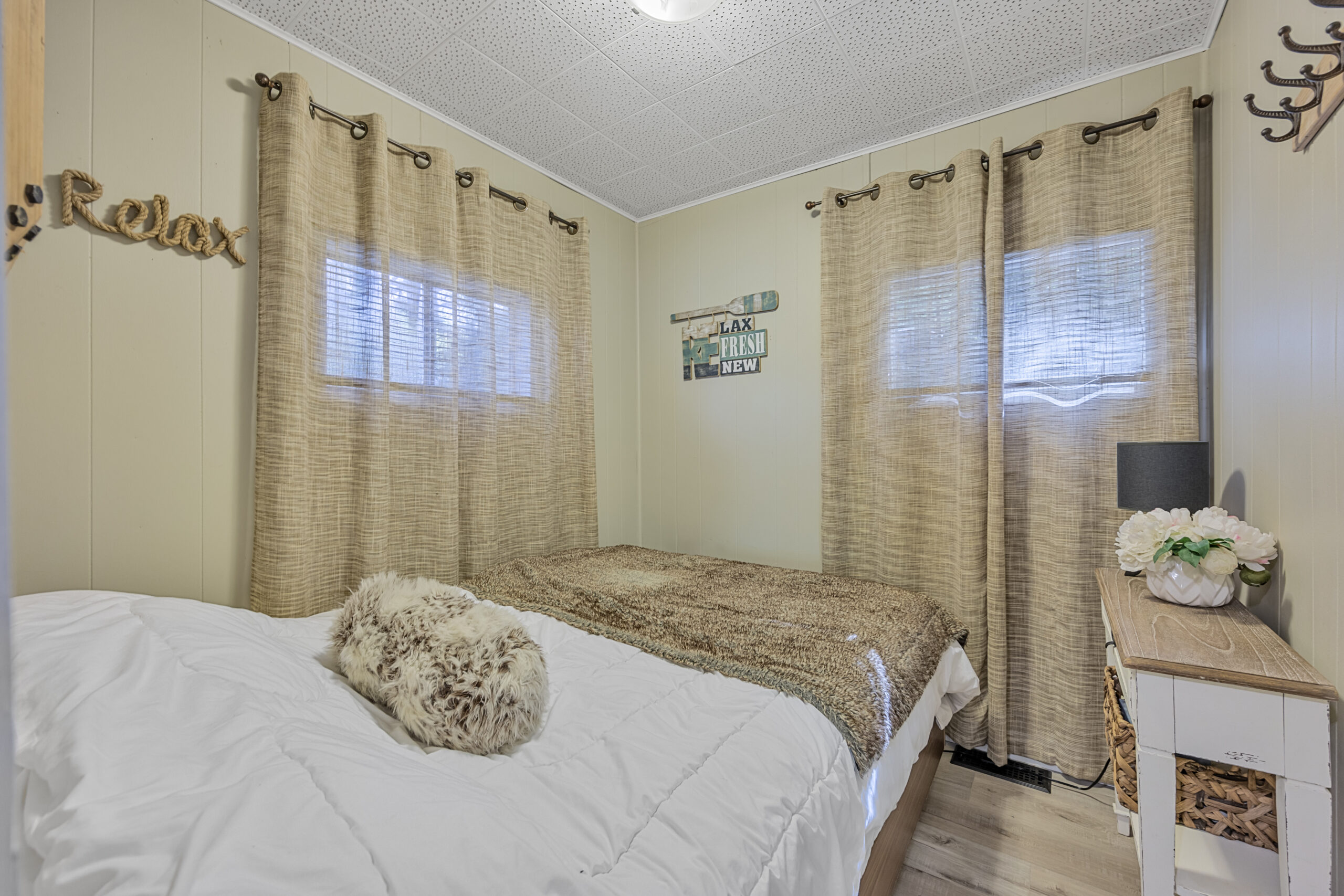 A small white bed with a fuzzy throw blanket