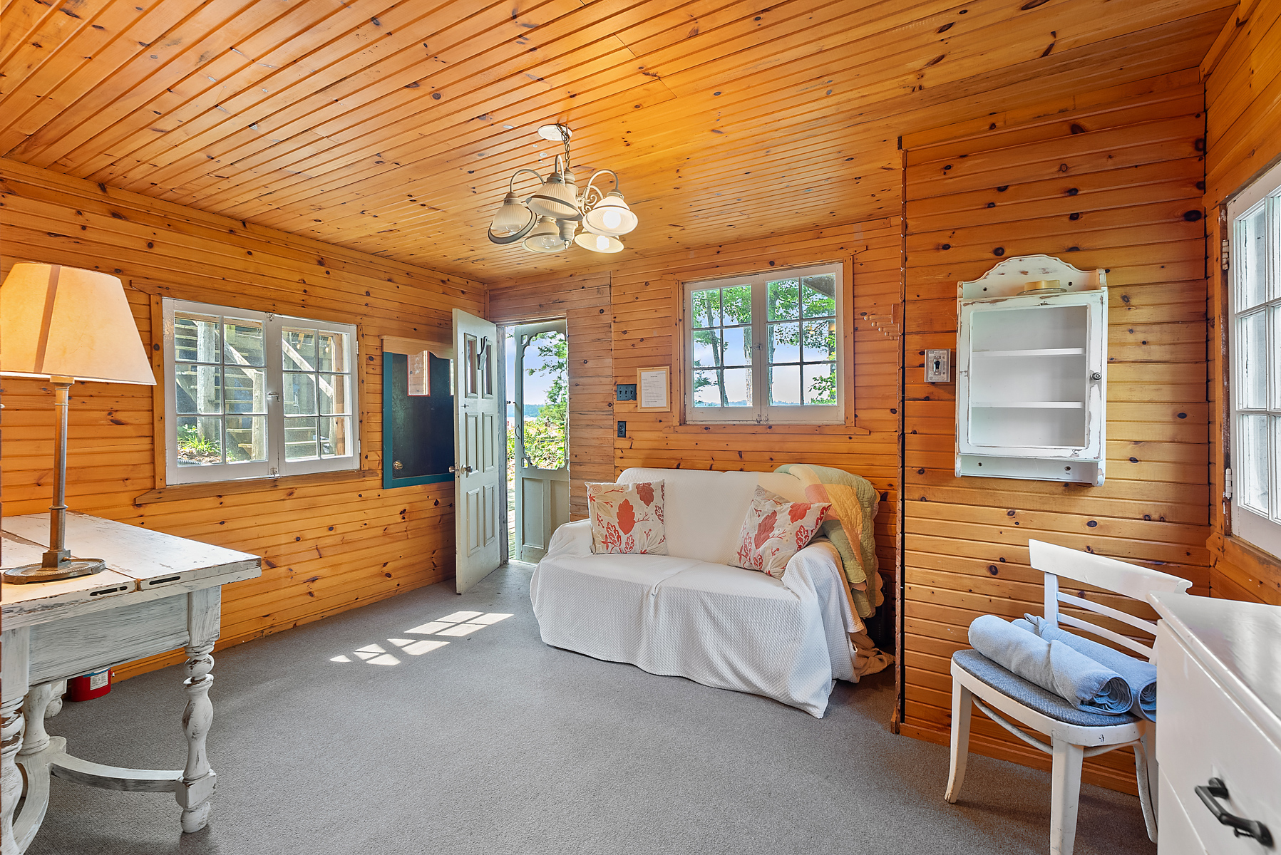 A white couch in a wood-paneled room