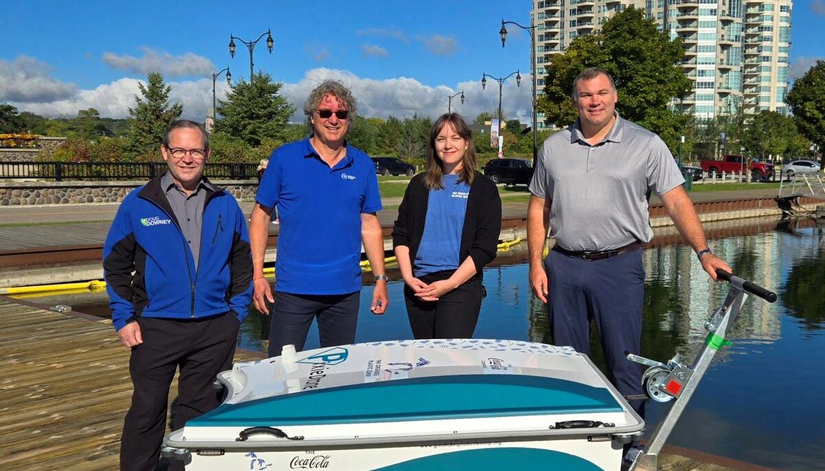 Pollution Probe employees stand with the mayor of Barrie in front of the PixieDrone, a garbage-collecting drone near Lake Simcoe