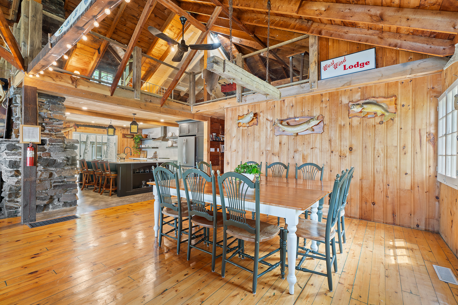 A large wood table with green chairs in a log cabin