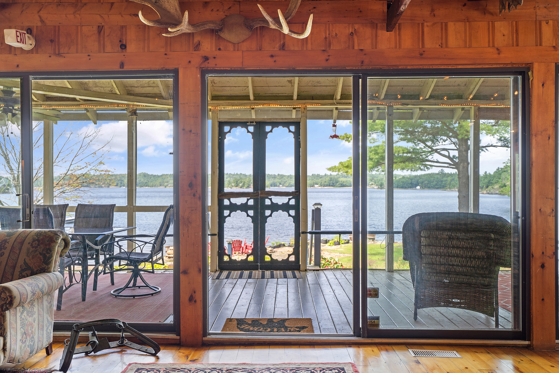 A screen door leading to a screened-in lakeside porch