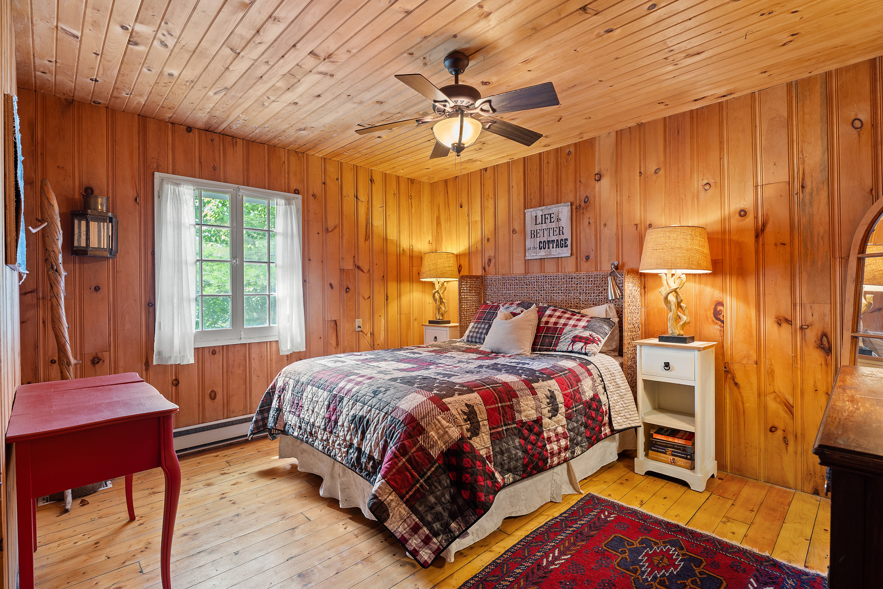 A plaid bed in a wood-paneled room