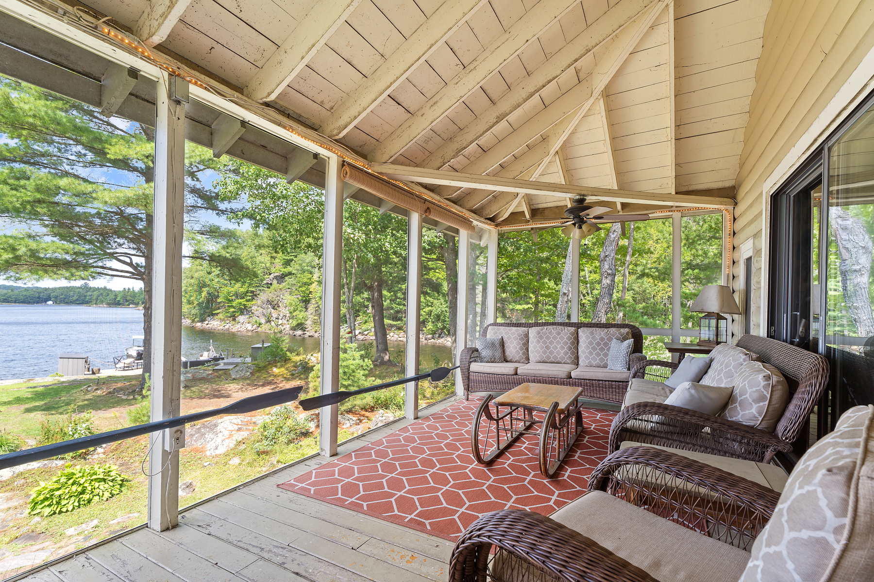 A couch in a bright screened-in porch