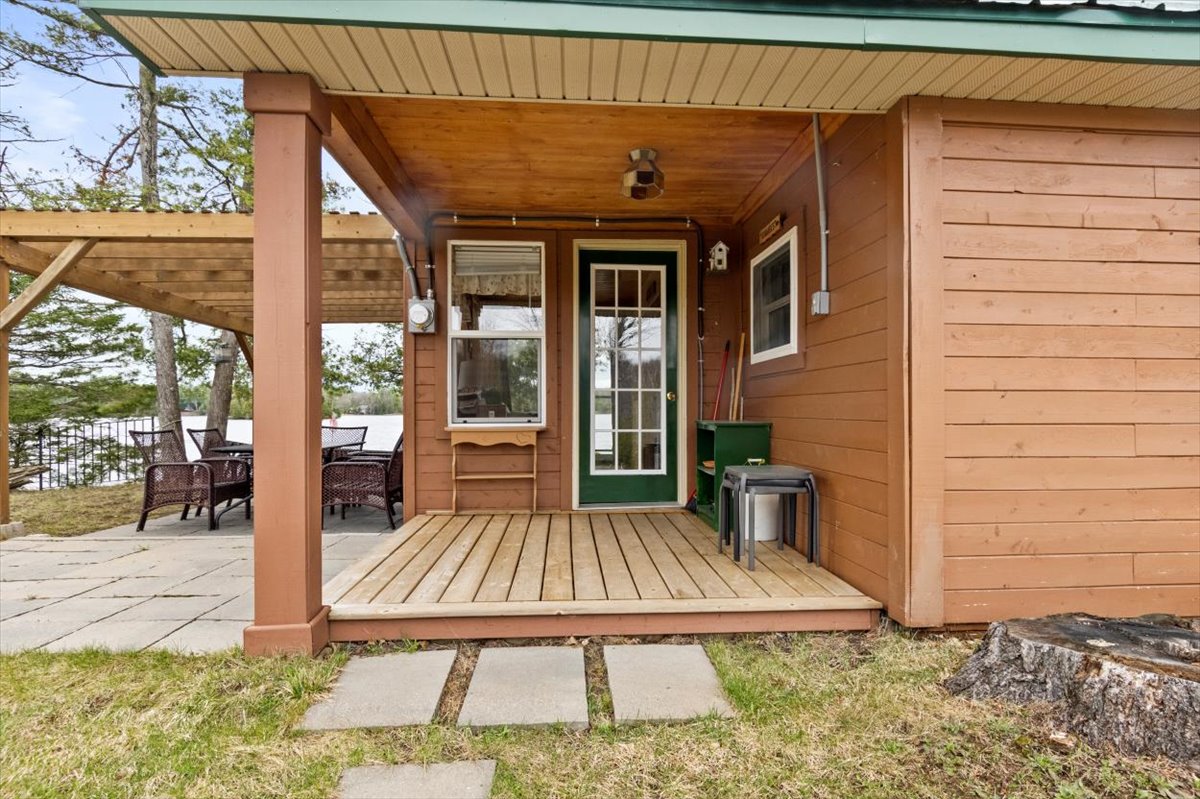 A covered front porch with a green front door
