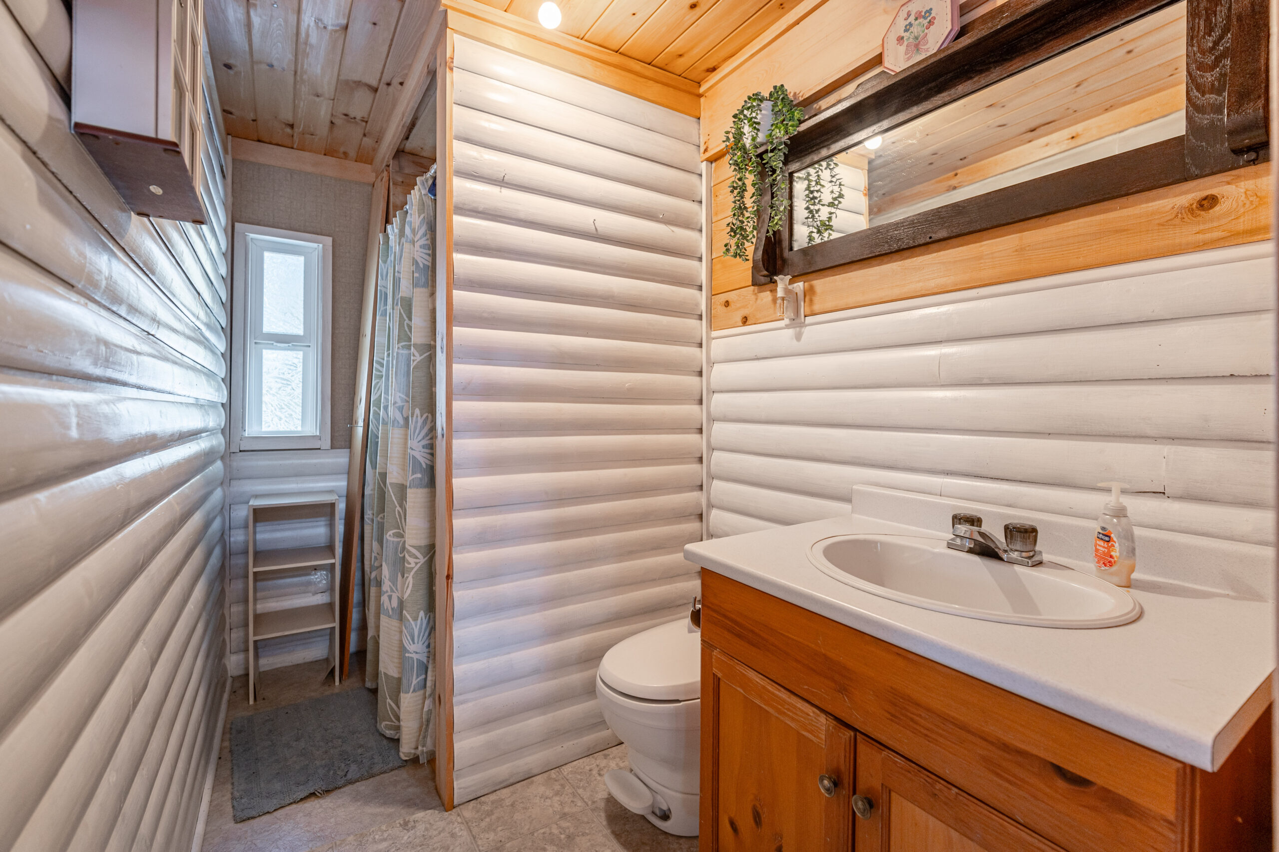 A small bathroom with white wood walls