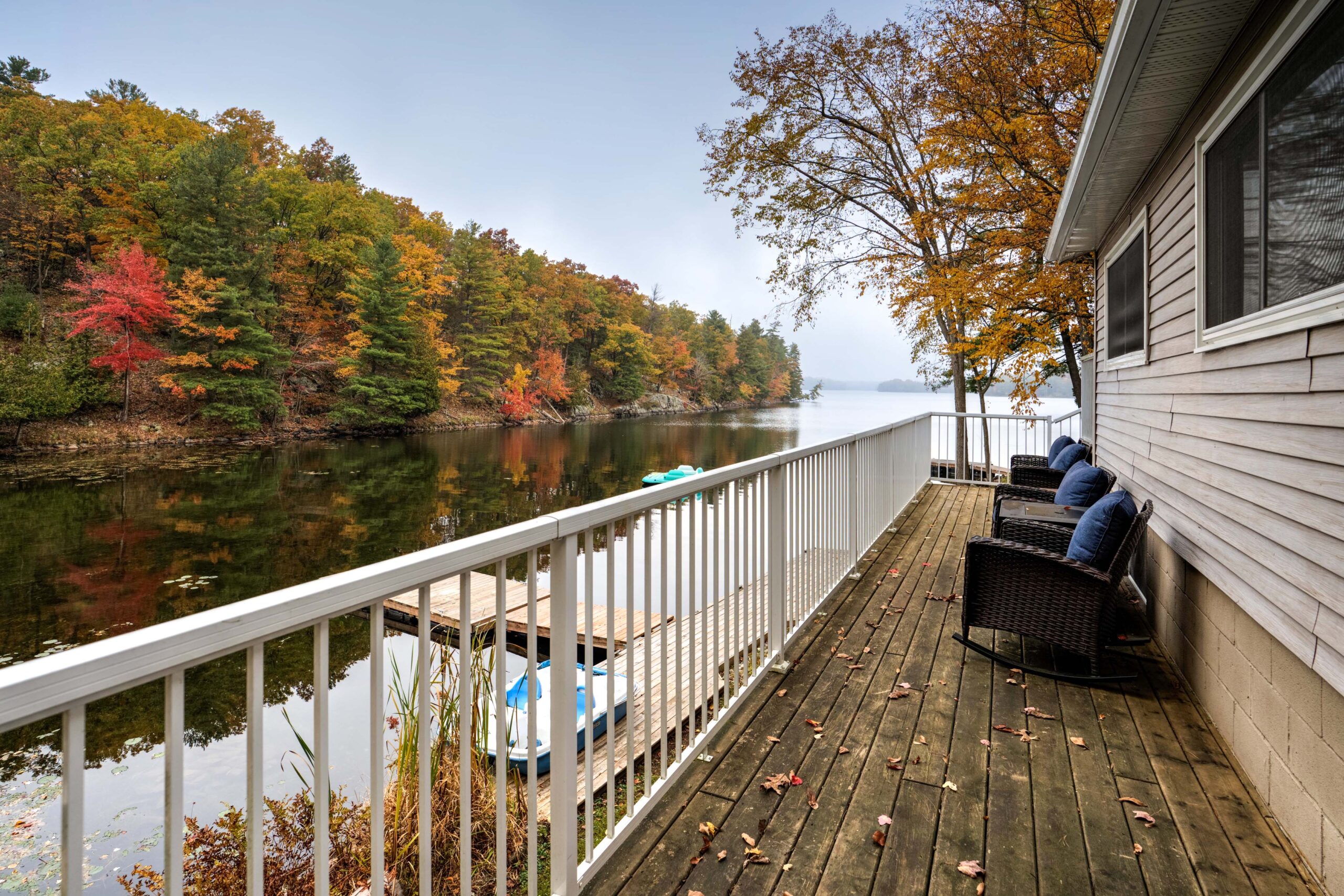 A long wood deck faces a lake