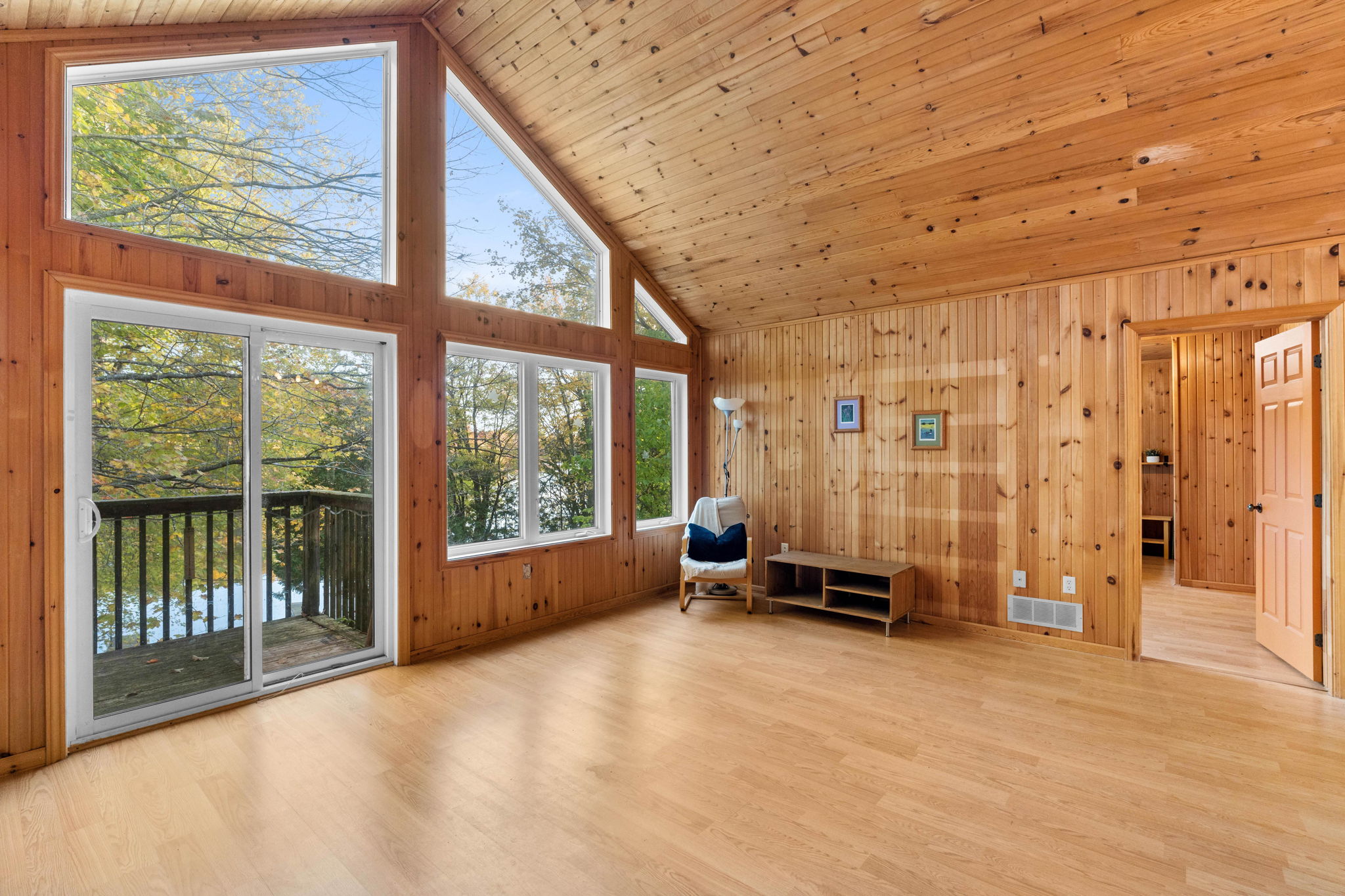 A spacious wood panelled room with vaulted ceilings and floor-to-ceiling windows