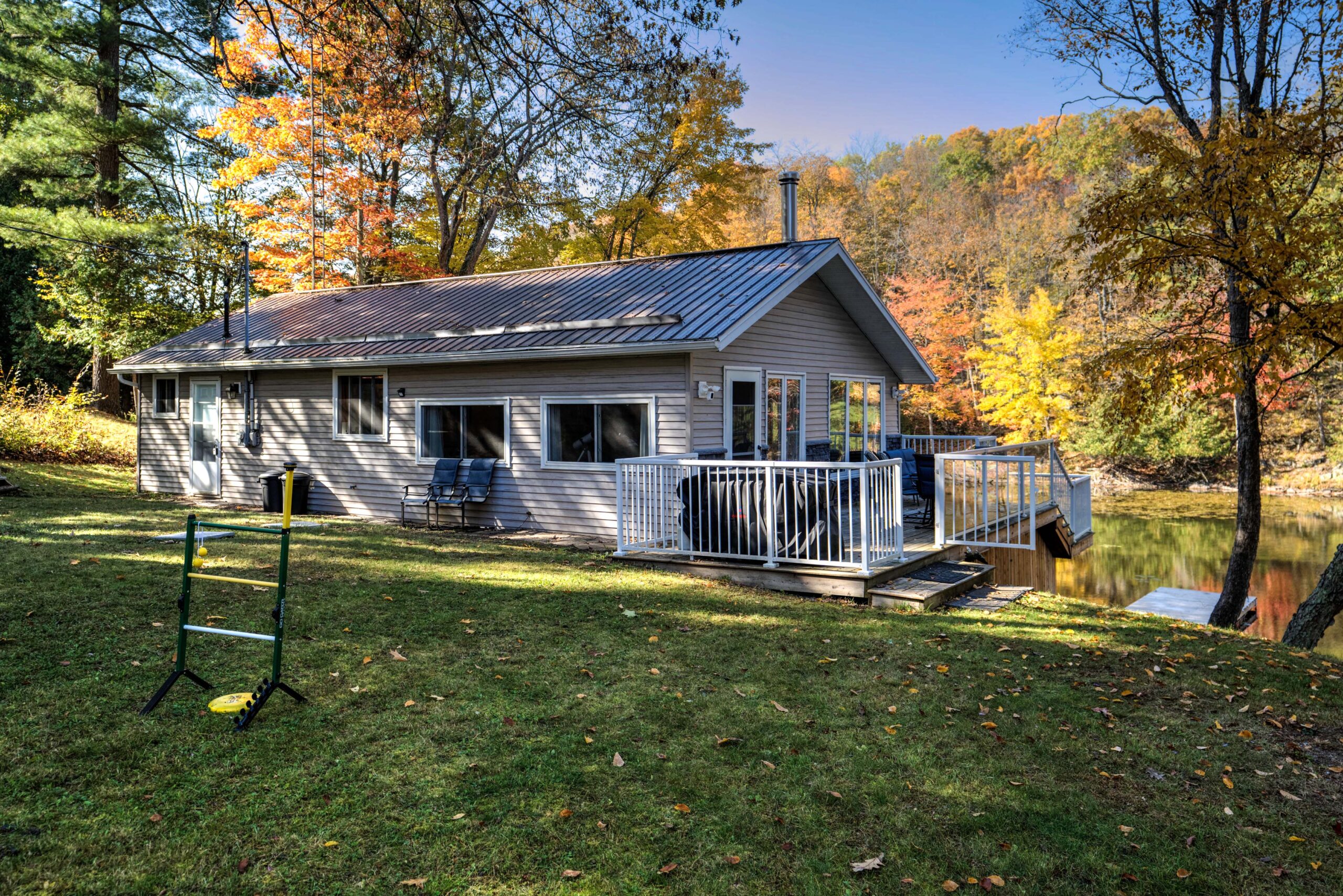 A beige bungalow cabin on a spacious lawn