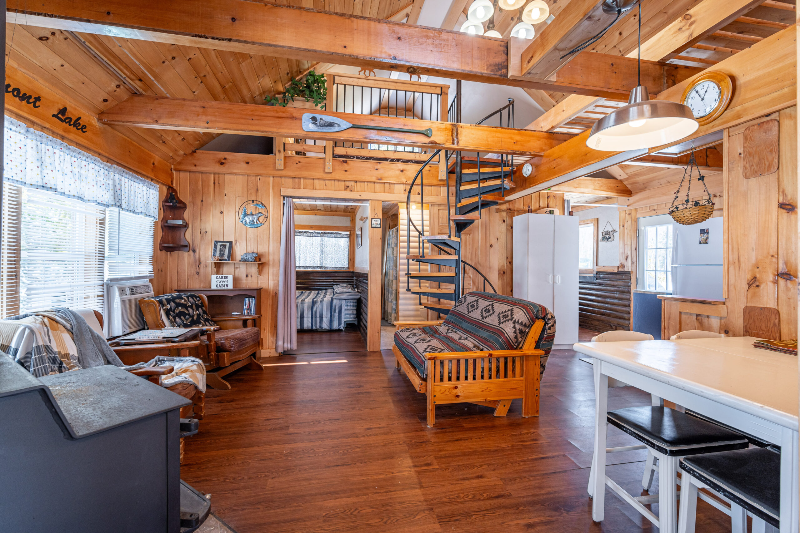 A couch faces two chairs in a log cabin