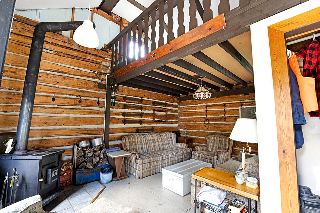 A plaid couch faces a coffee table in a wood-panelled room