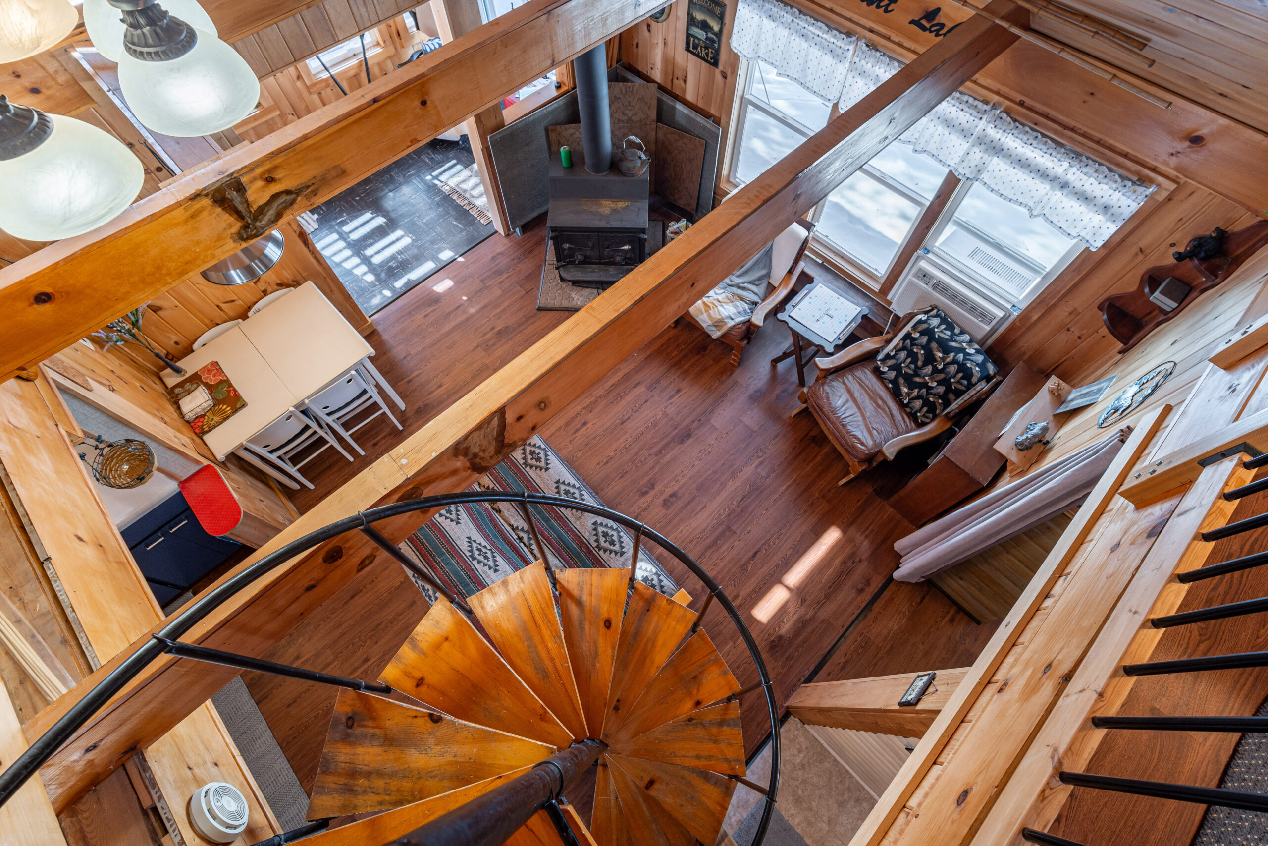 From the top, a spiral staircase looks down into a living room