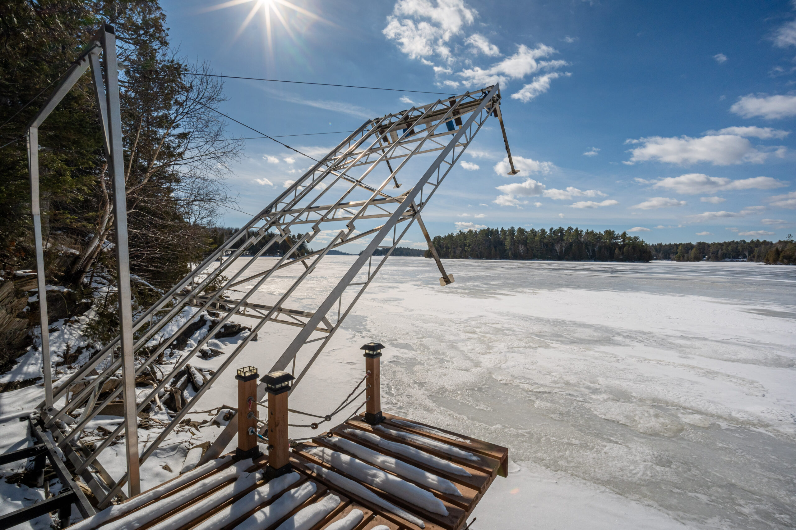 A metal frame is partially lifted out of a frozen lake