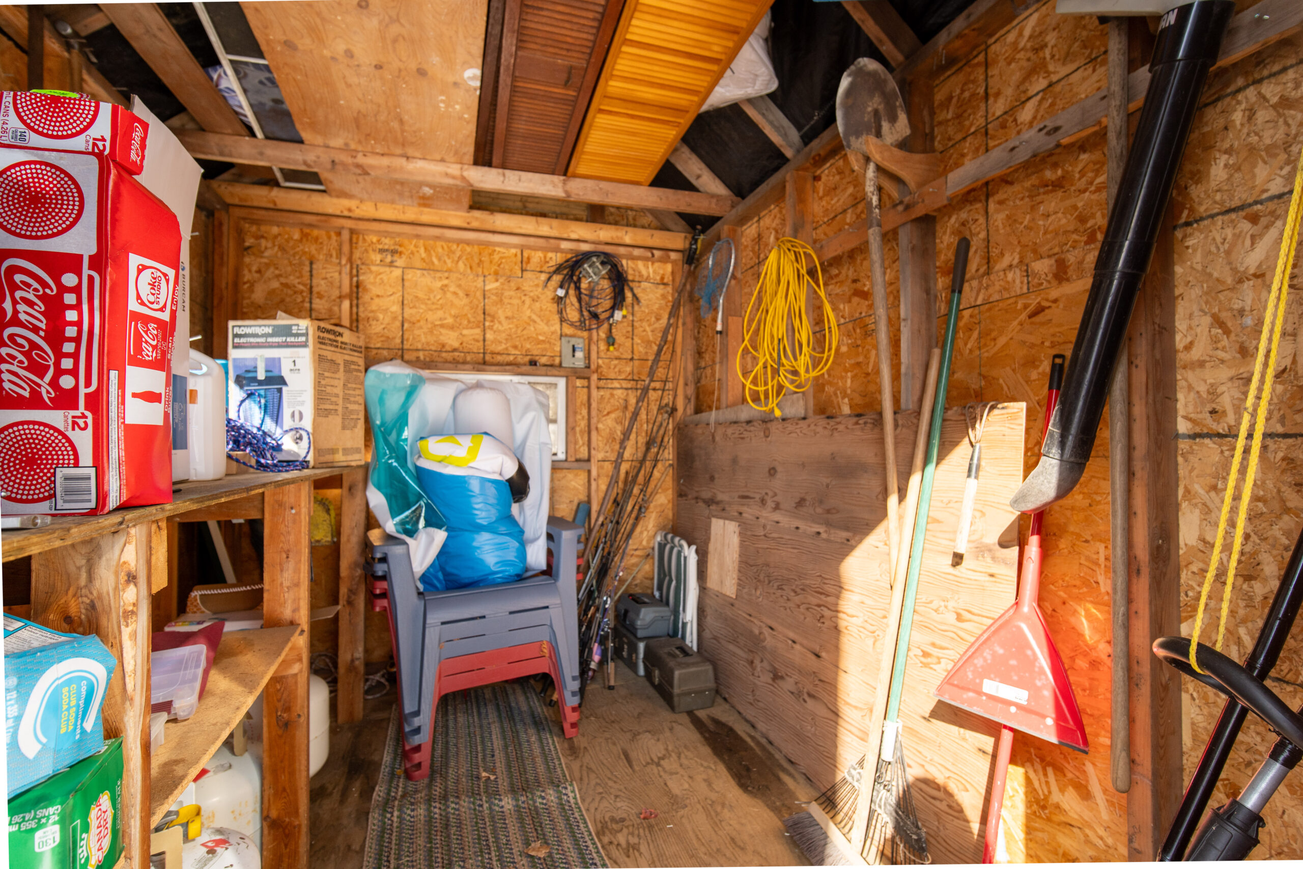 The inside of a wood shed filled with garden tools