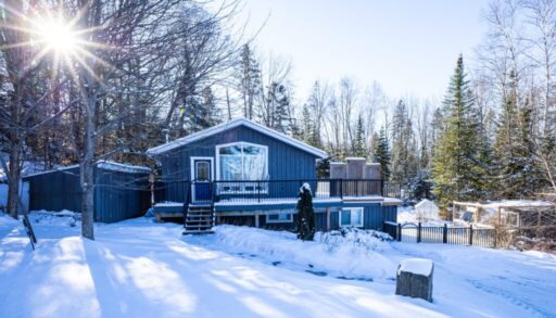 a blue cottage among a snowy landscape