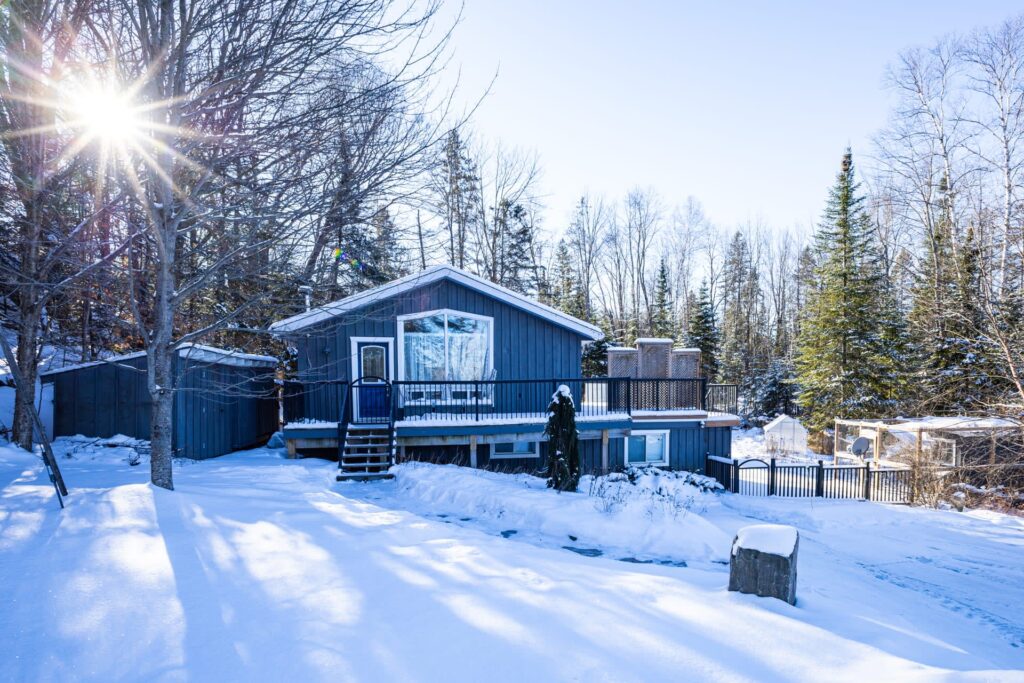 a blue cottage among a snowy landscape