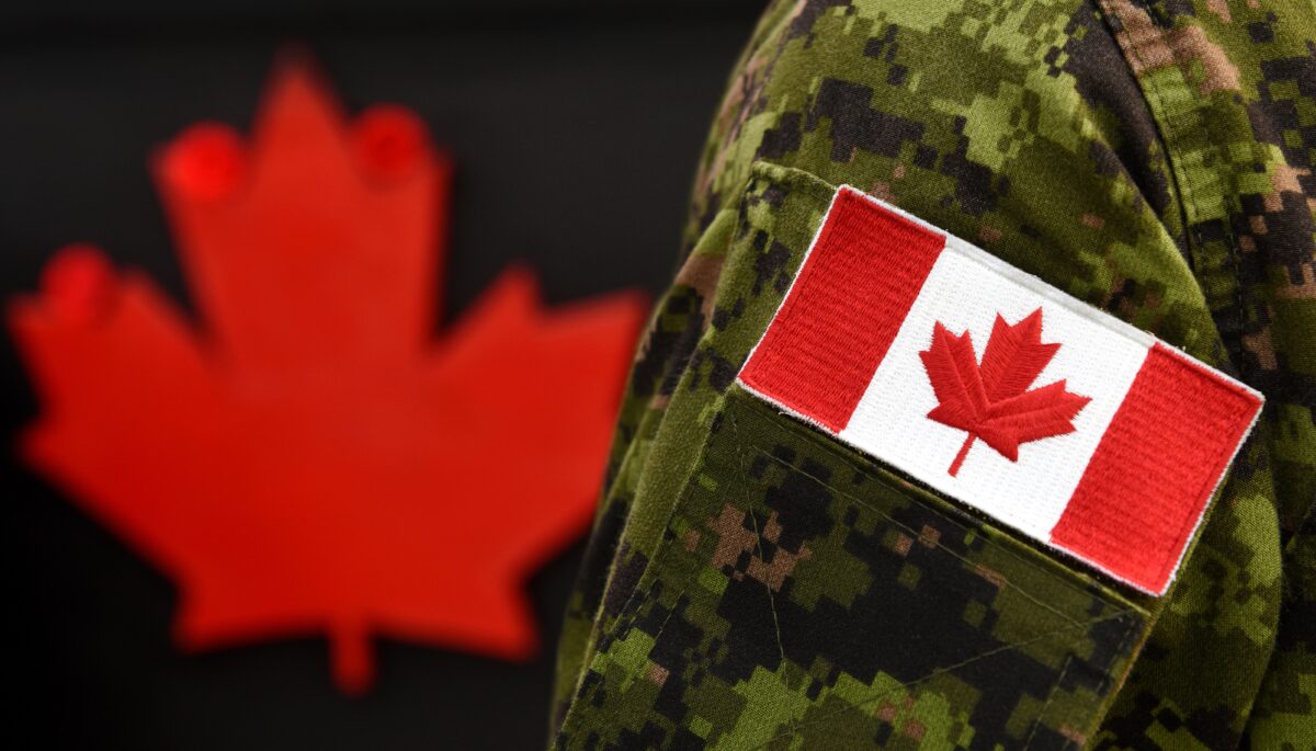 a Canadian flag on the arm of a military uniform