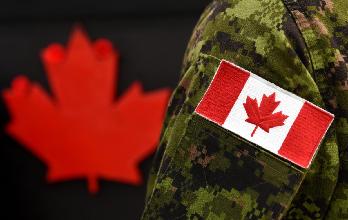 a Canadian flag on the arm of a military uniform