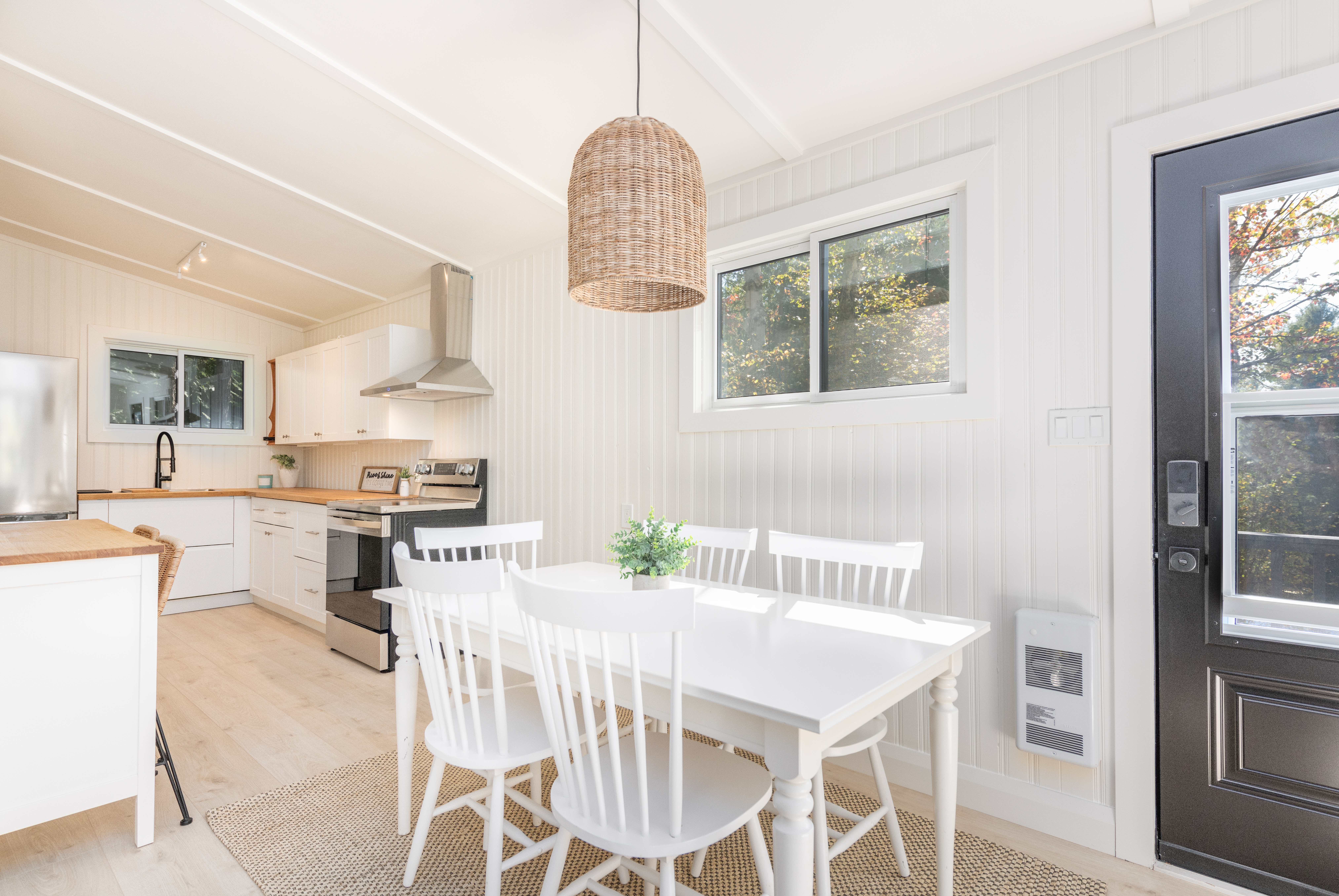 A white wood dining table in a white room