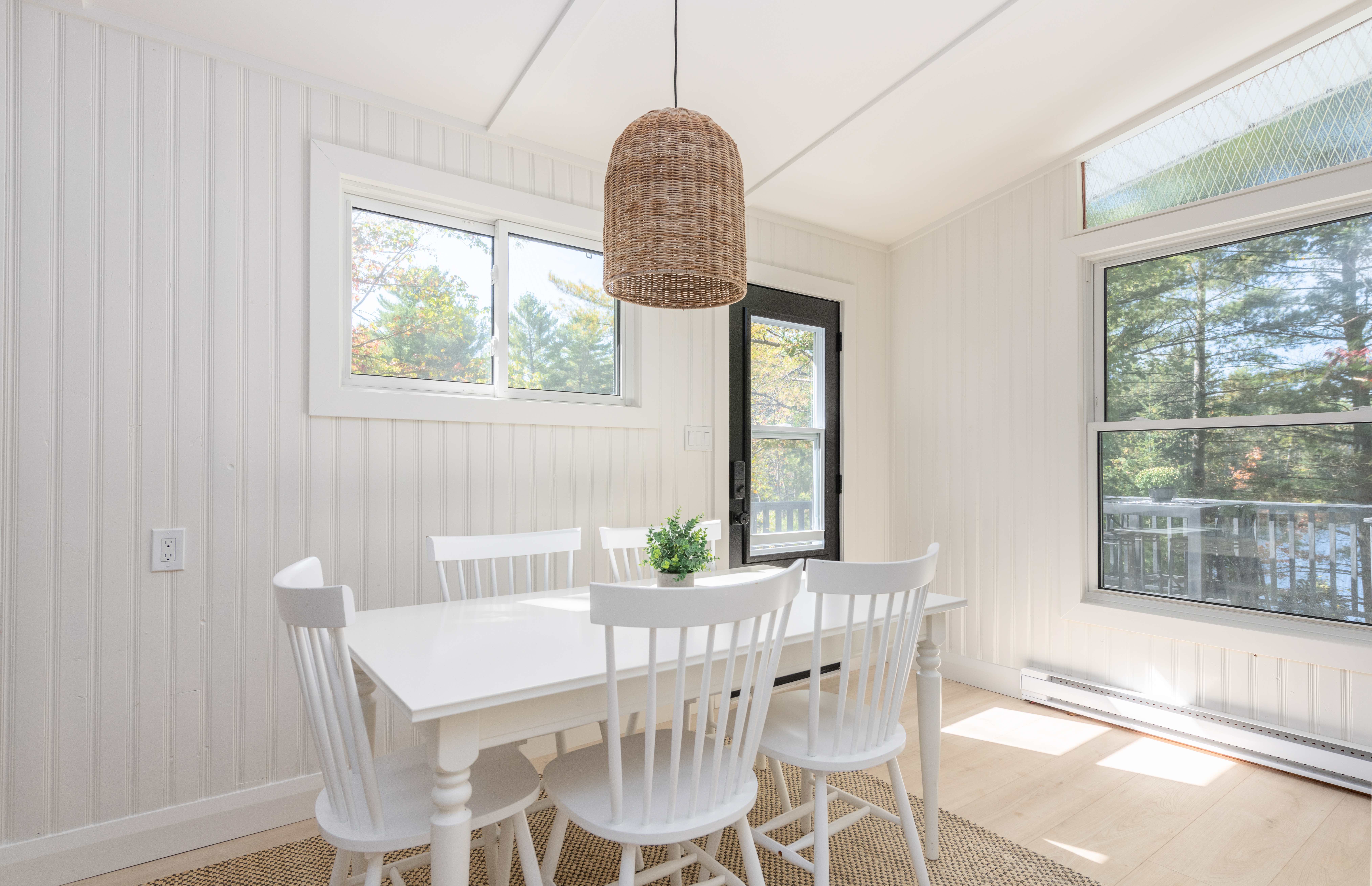 A white wood dining table in a white room