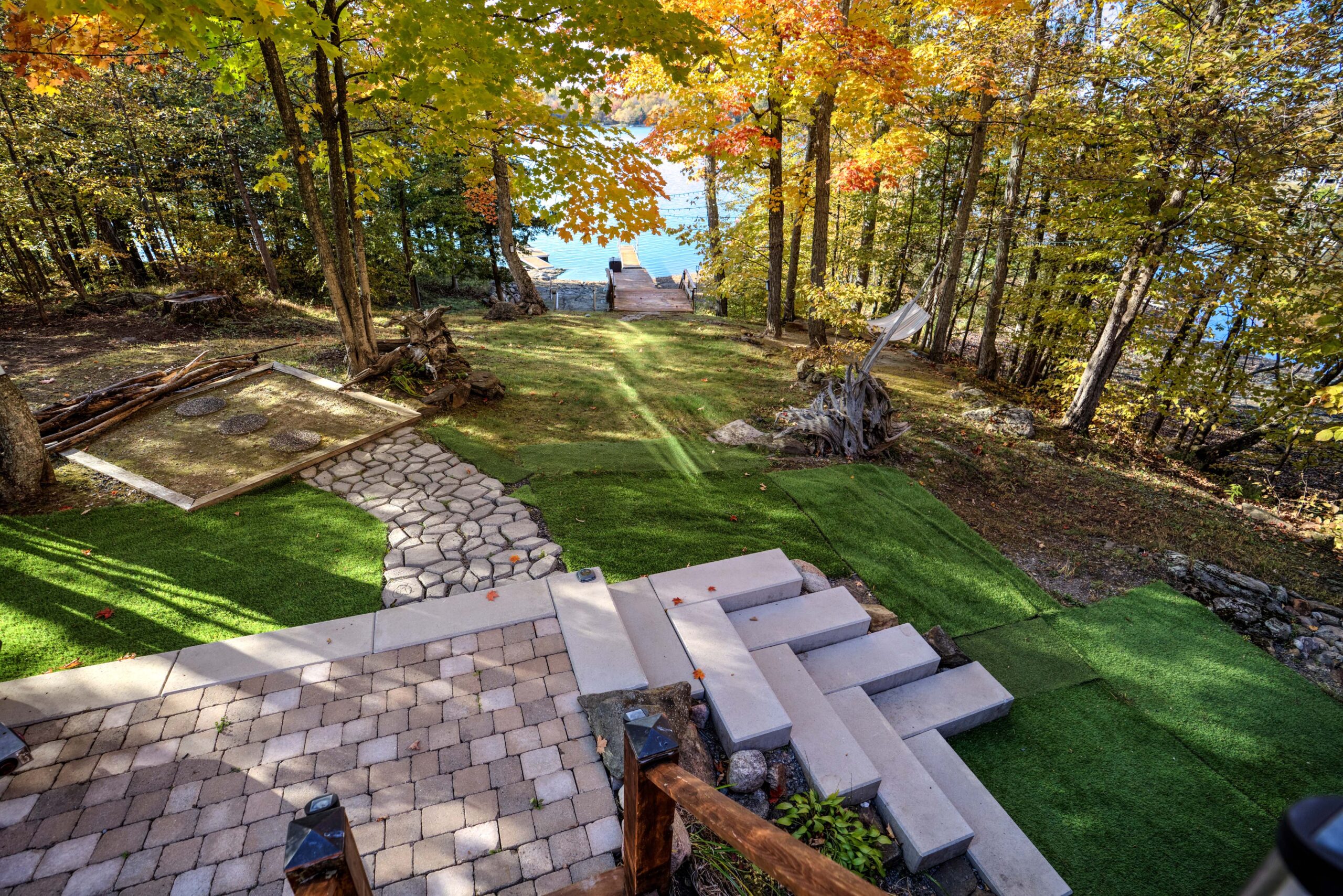 A fake grass yard with steps to the water