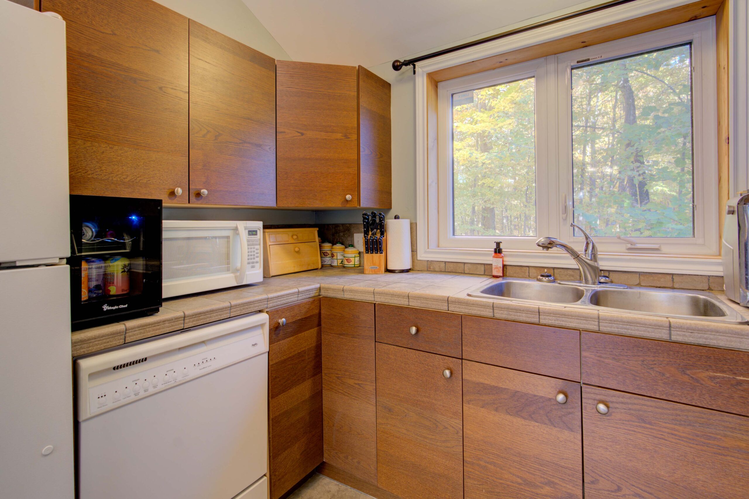 A kitchen with brown wood cabinets and white appliances