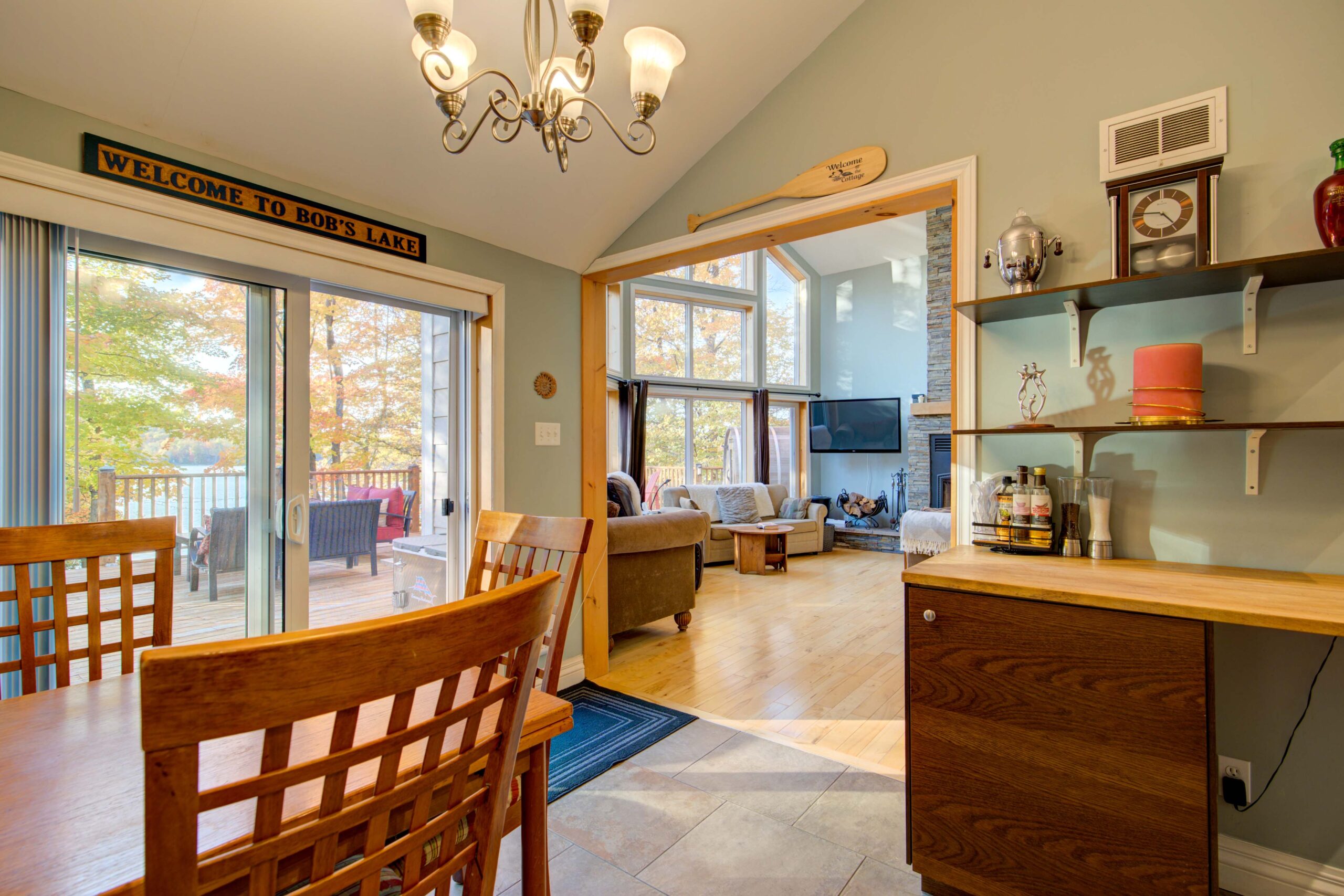 A small wood dining area looks into a large room with couches