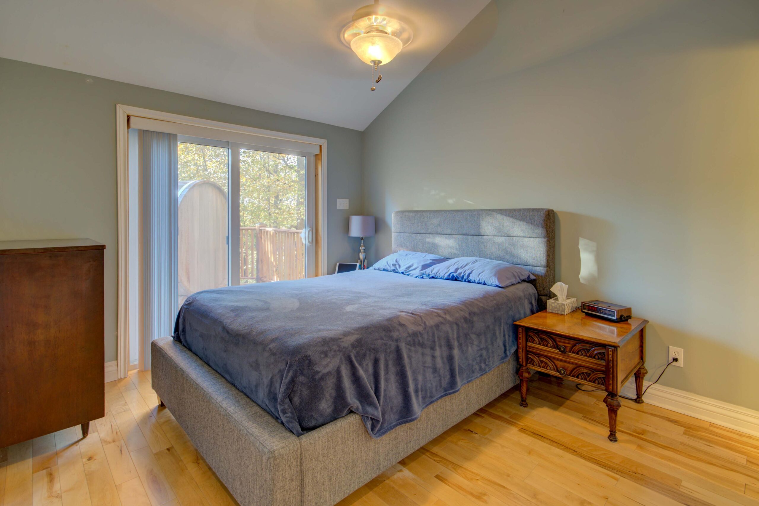 A large bed with a grey bedspread