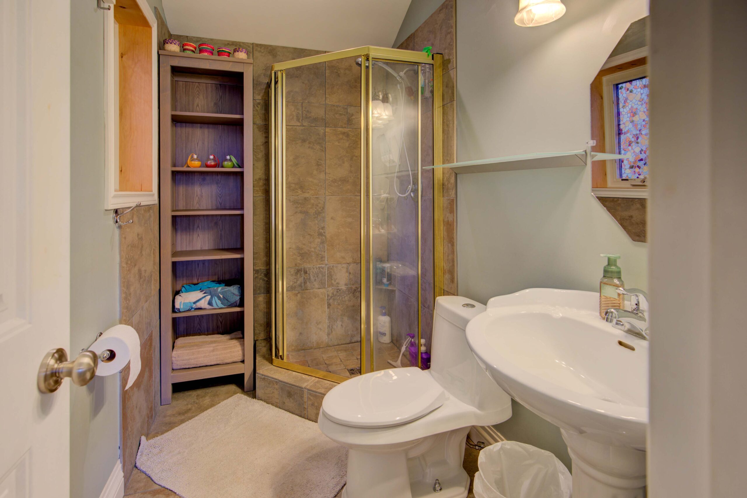 A brown marble kitchen with a walk-in shower and white bathroom appliances