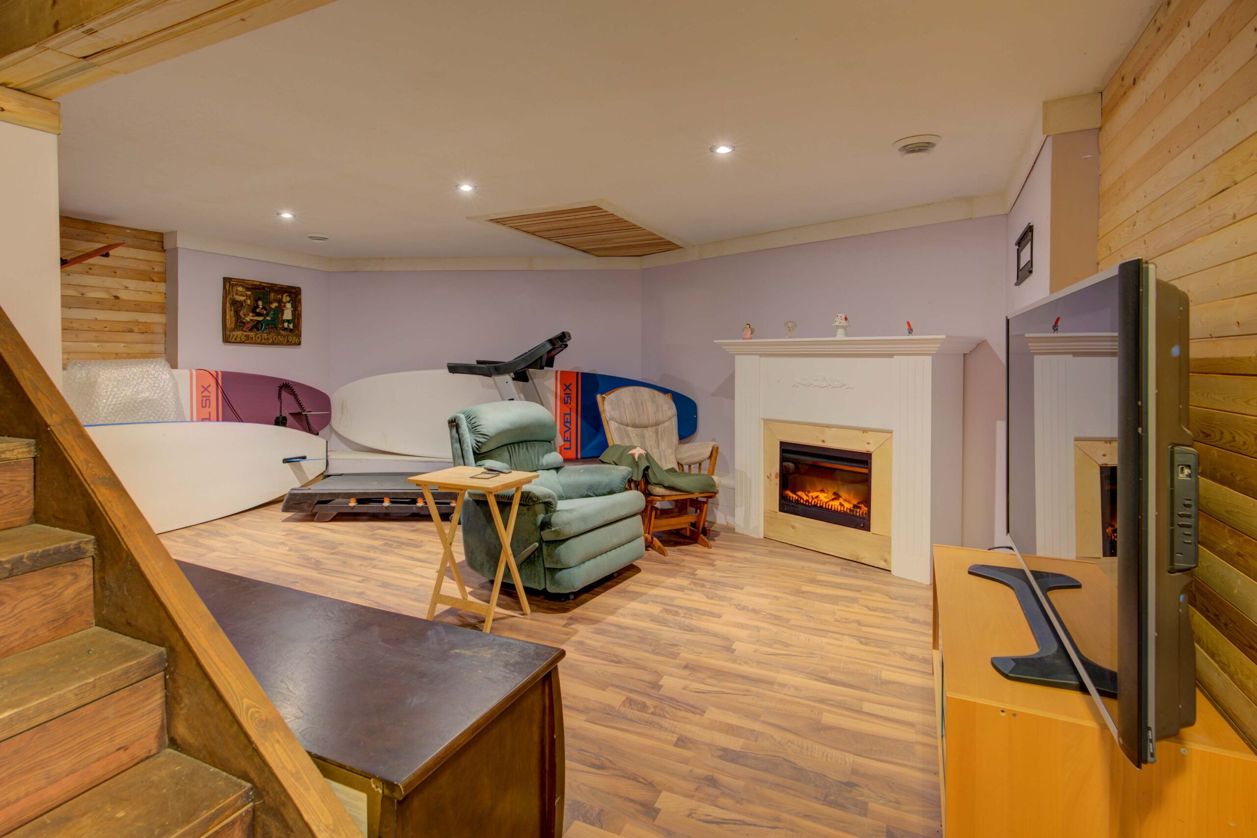 A green chair faces a built-in fireplace in an empty room