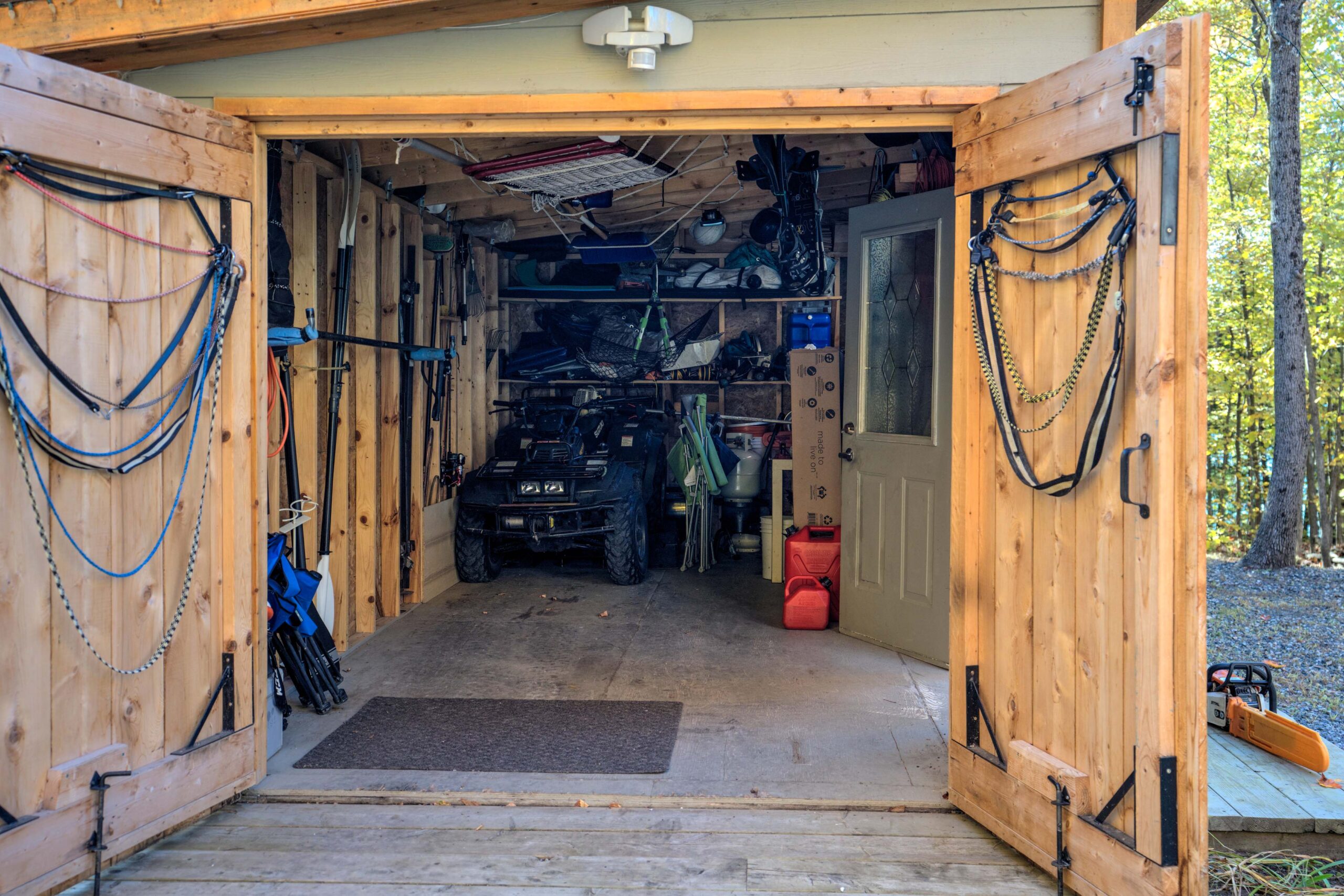 Open double doors lead into a spacious storage shed
