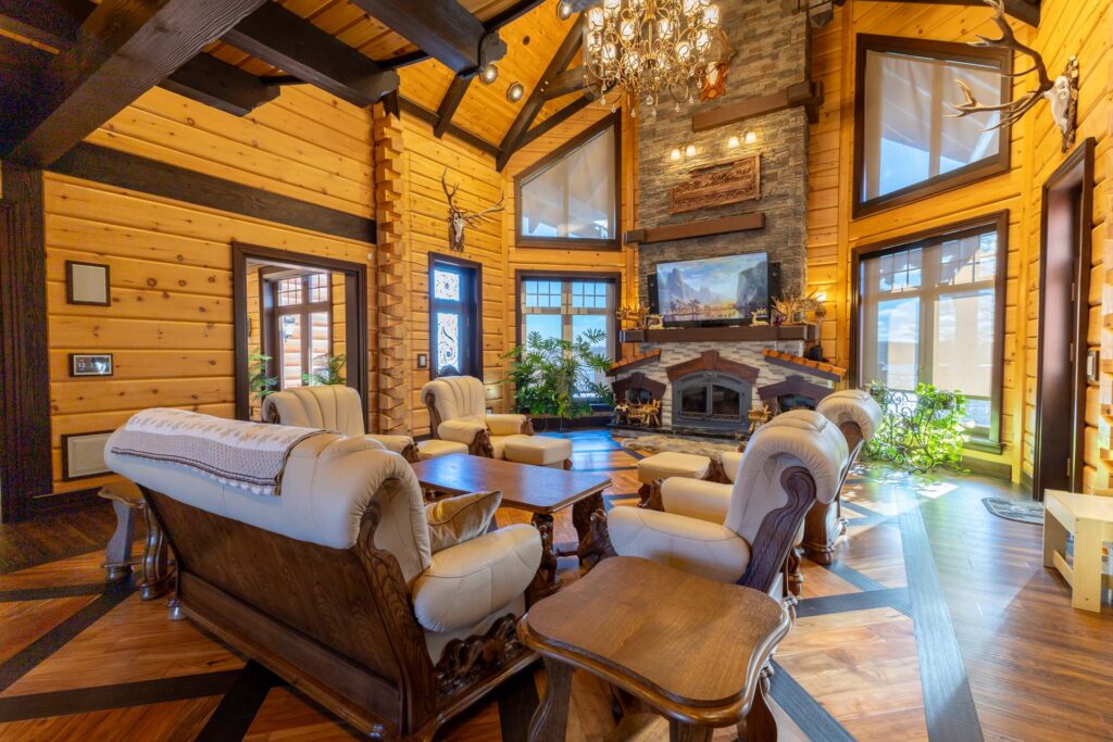 Wood furniture with white cushions face each other in a grand living room with vaulted ceilings