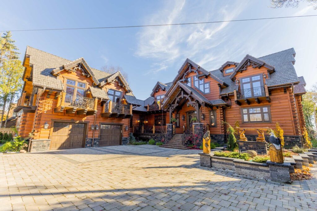 A huge orange cottage with brown trim and a large stone driveway