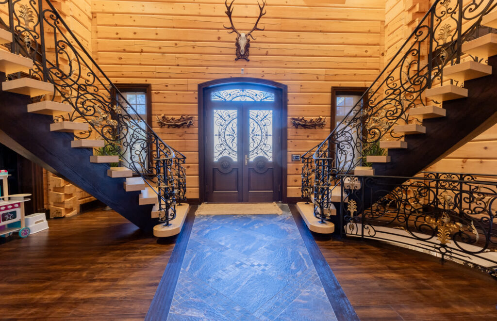 A spacious entryway with a long carpet framed by two staircases going up