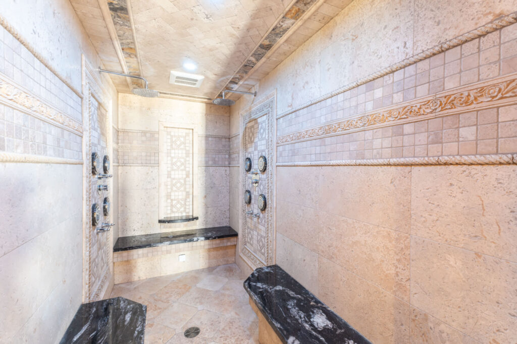 a photo of a wet sauna with showers and bench seats